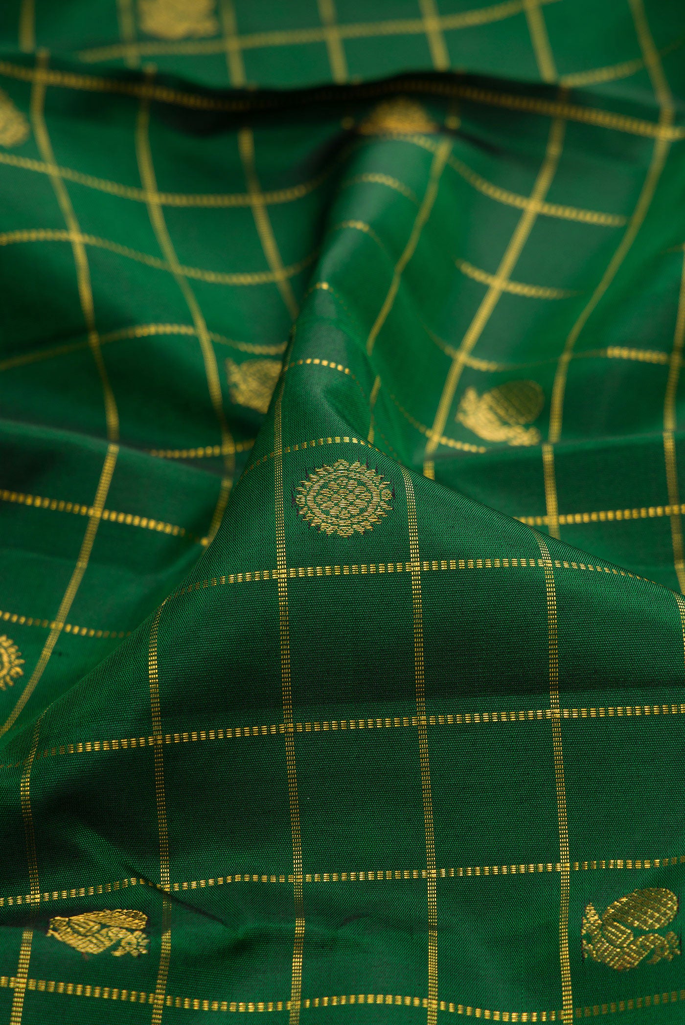 Close up of Bottle Green Kanjivaram Silk Saree with Checked design on the body and Zari Border.  displaying folds