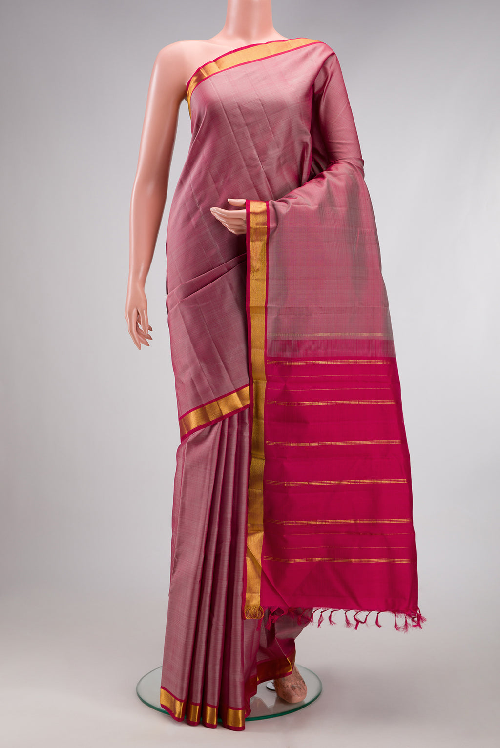 Rose Gold Kanjivaram Silk Saree with Plain Body and Zari Border.  displayed on a mannequin