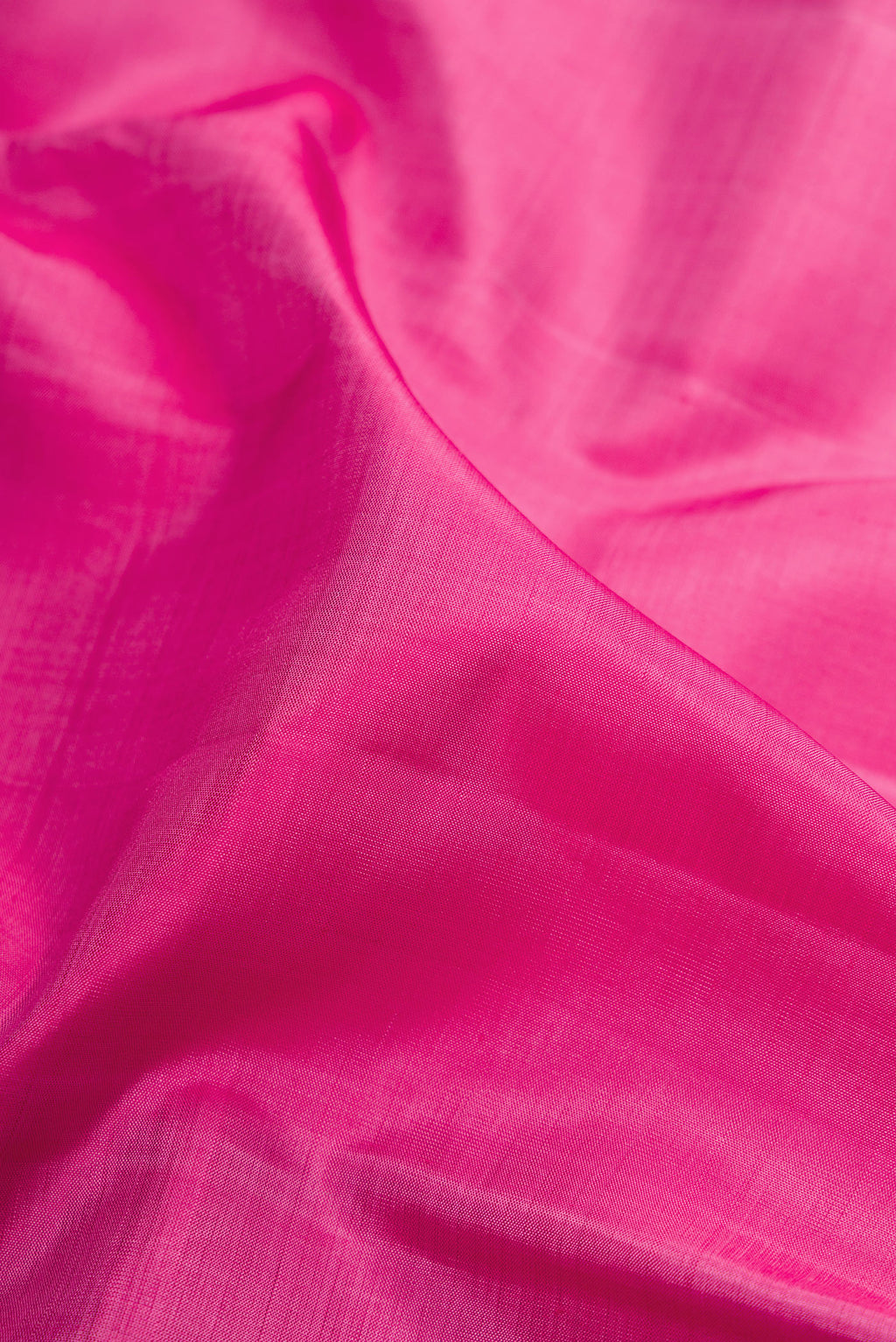 Close up of Pink Kanjivaram Silk Saree with Plain Body and Zari Border.  displaying folds