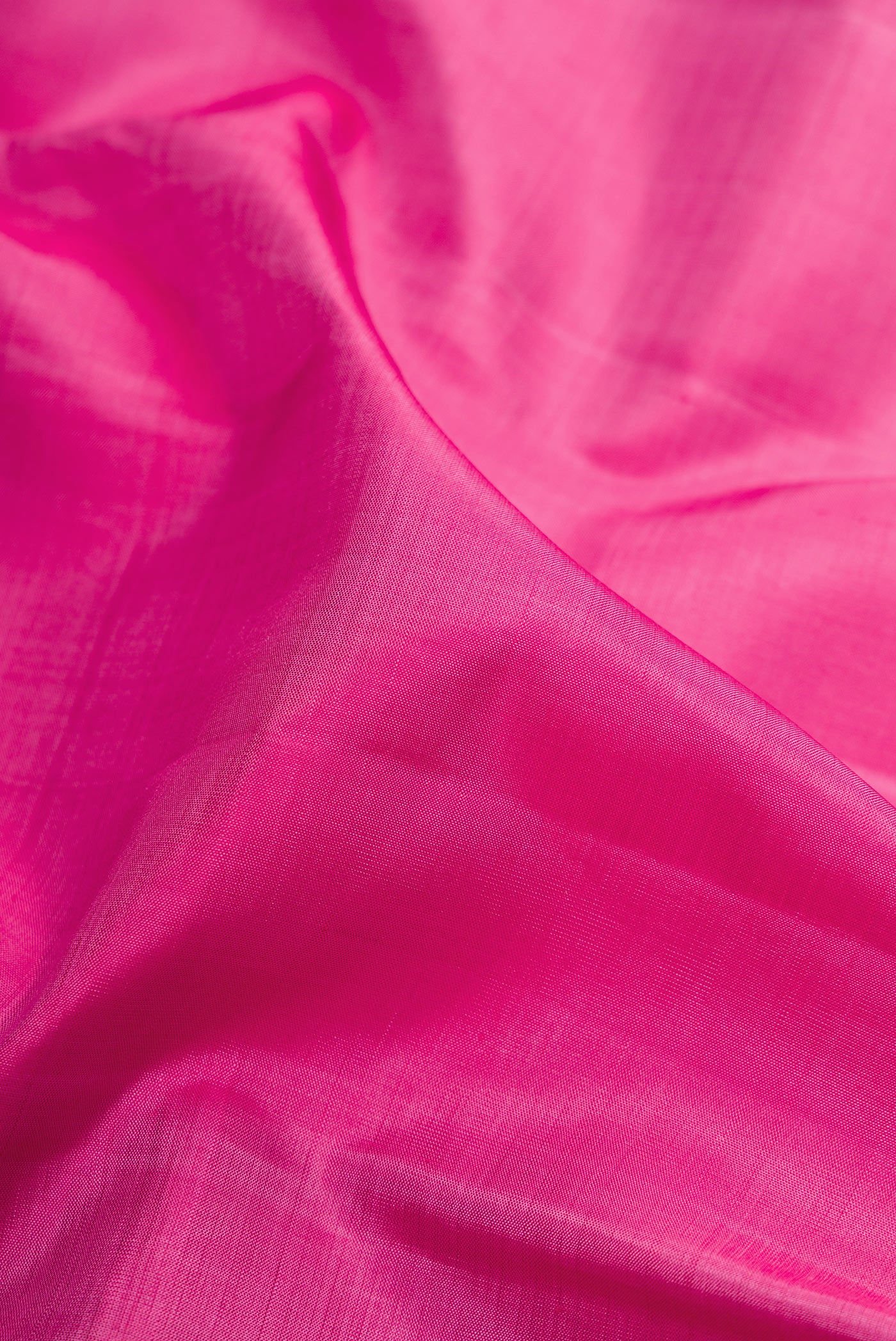 Close up of Pink Kanjivaram Silk Saree with Plain Body and Zari Border.  displaying folds