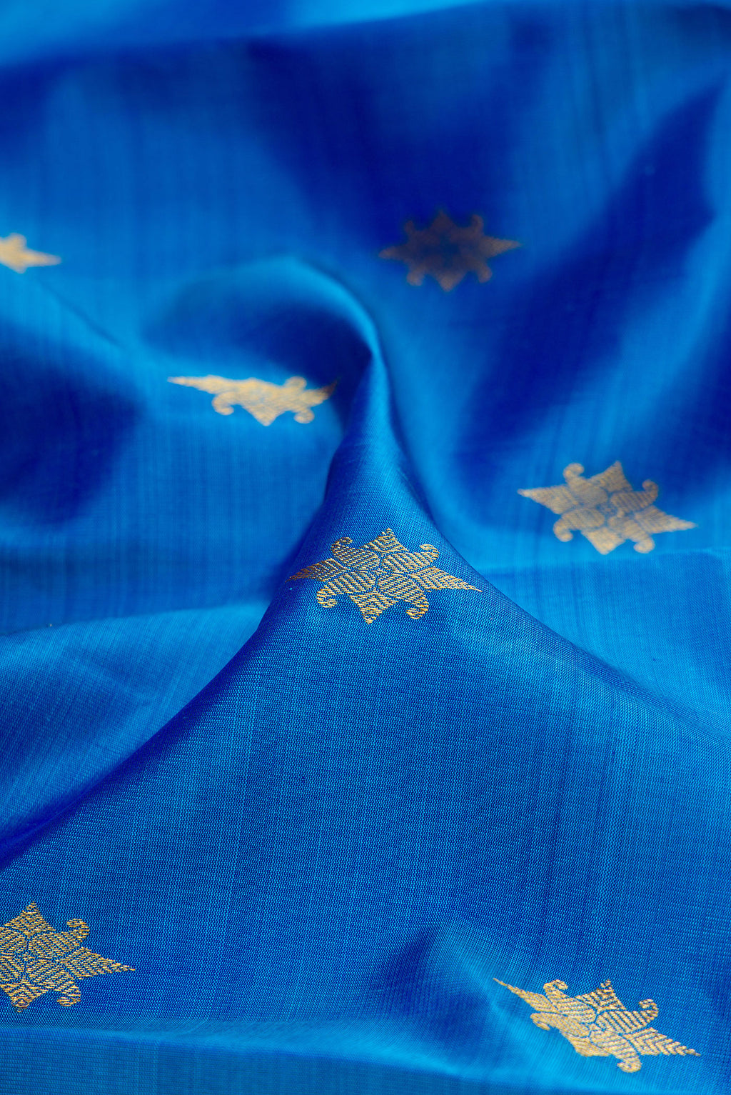 Close up of Royal Blue Kanjivaram Silk Saree with Zari Butta on the body and Zari Border.  displaying folds