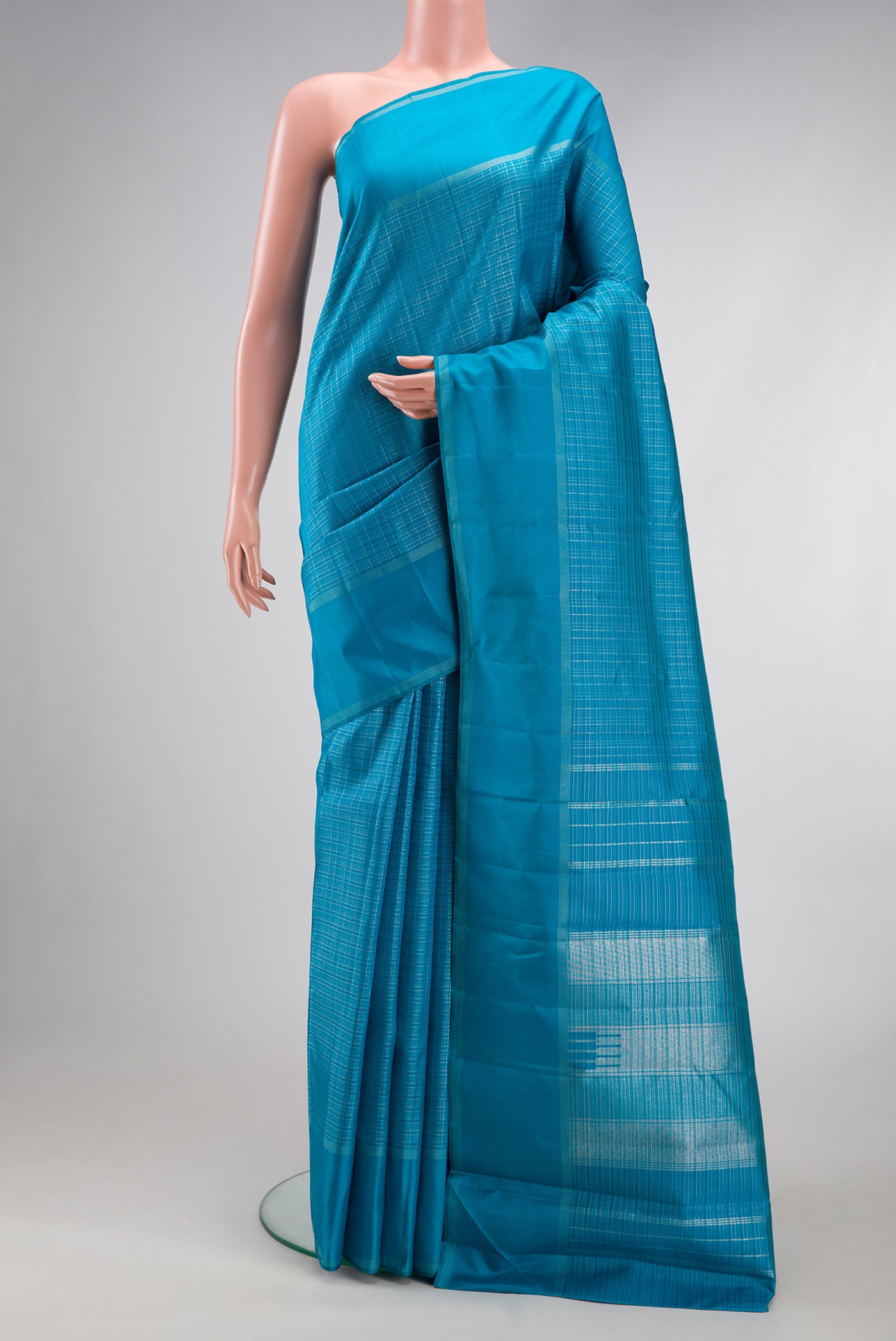 Sky Blue Kanchipuram Silk Saree with Checked design on the body and Zari Border.  displayed on a mannequin