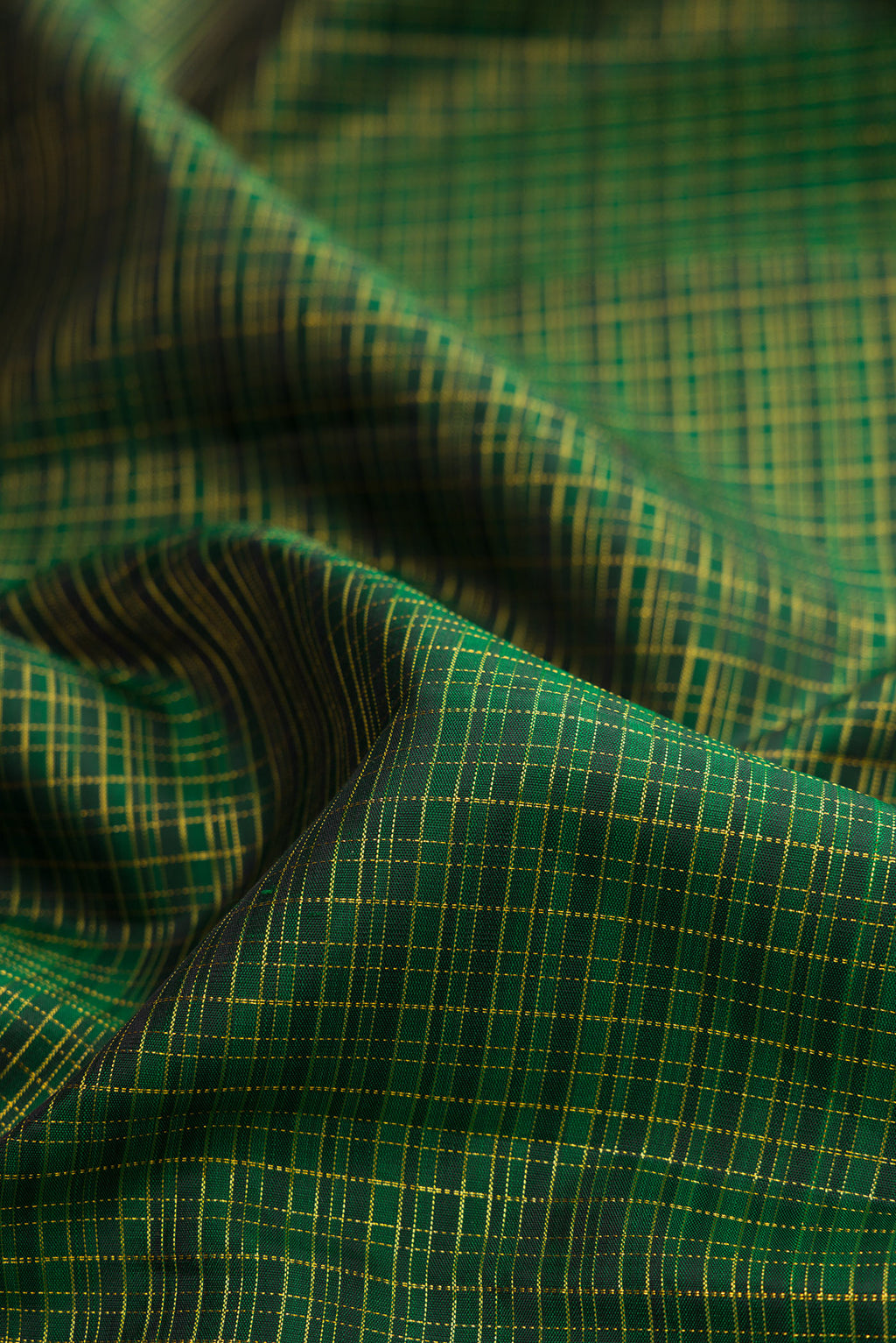 Close up of Pure Silk Bottle Green Kanchipuram Saree with Checked design on the body and Plain Border.  displaying folds