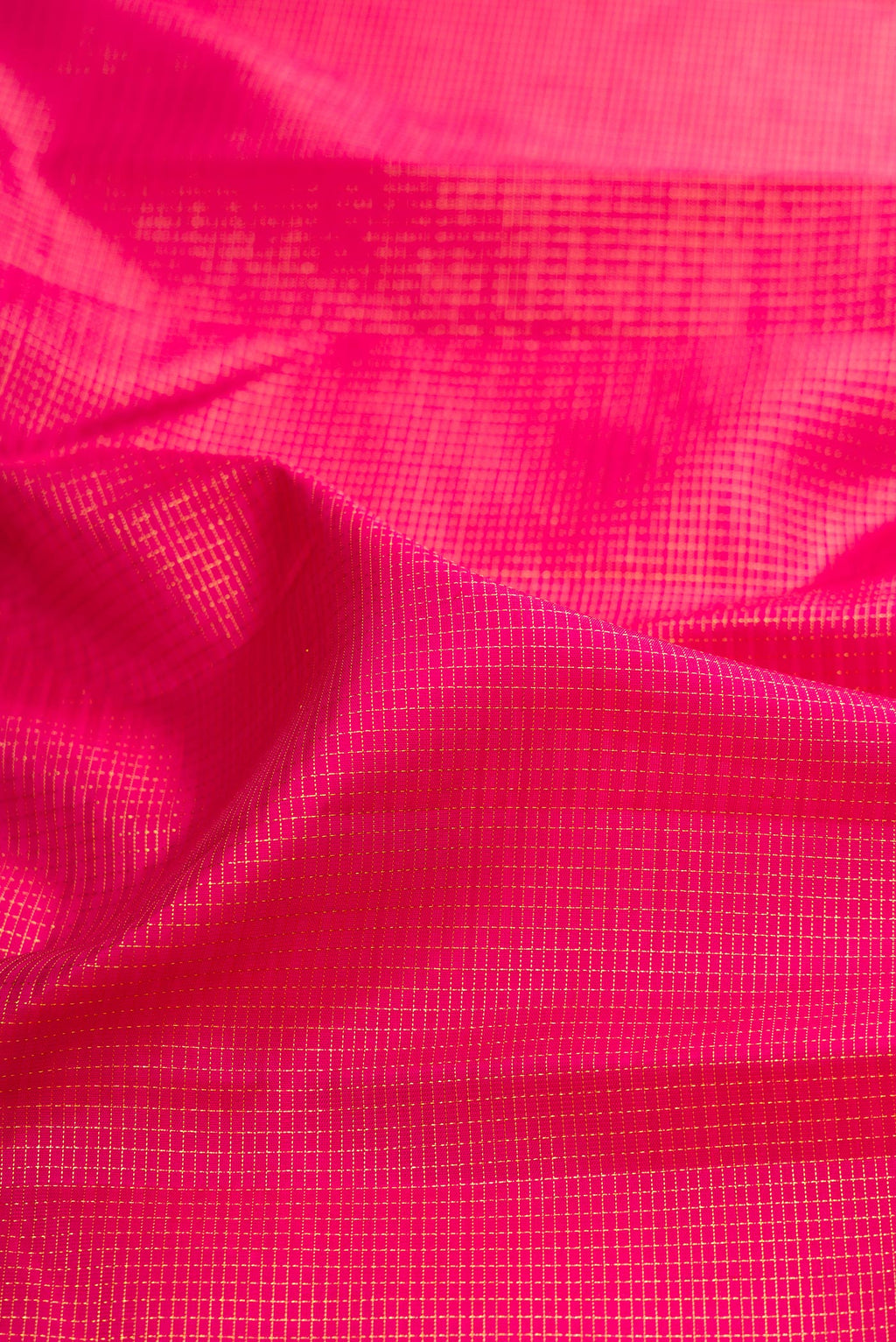 Close up of Dark Pink Kanchipuram Silk Saree with Checked design on the body and Zari Border.  displaying folds