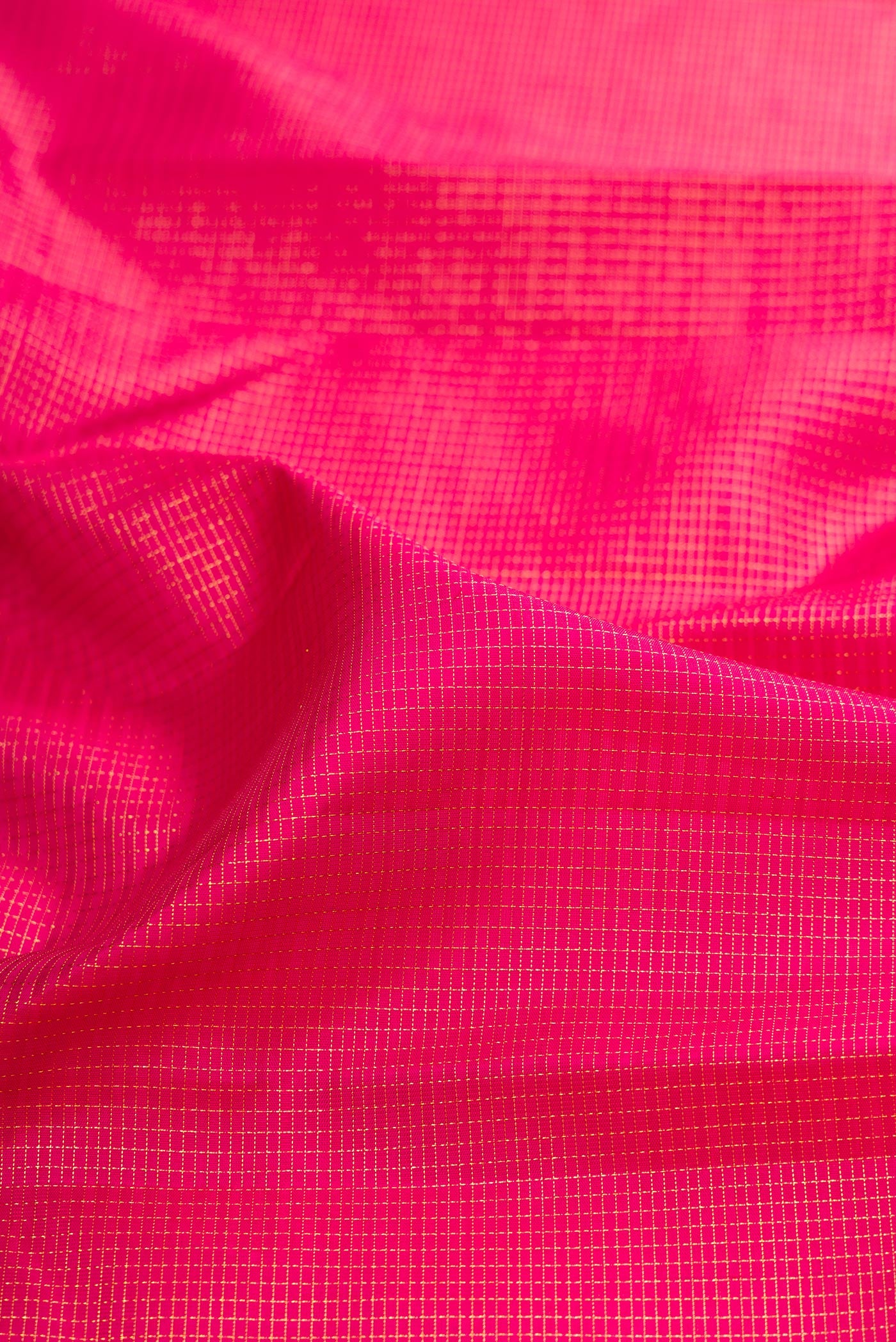 Close up of Dark Pink Kanchipuram Silk Saree with Checked design on the body and Zari Border.  displaying folds