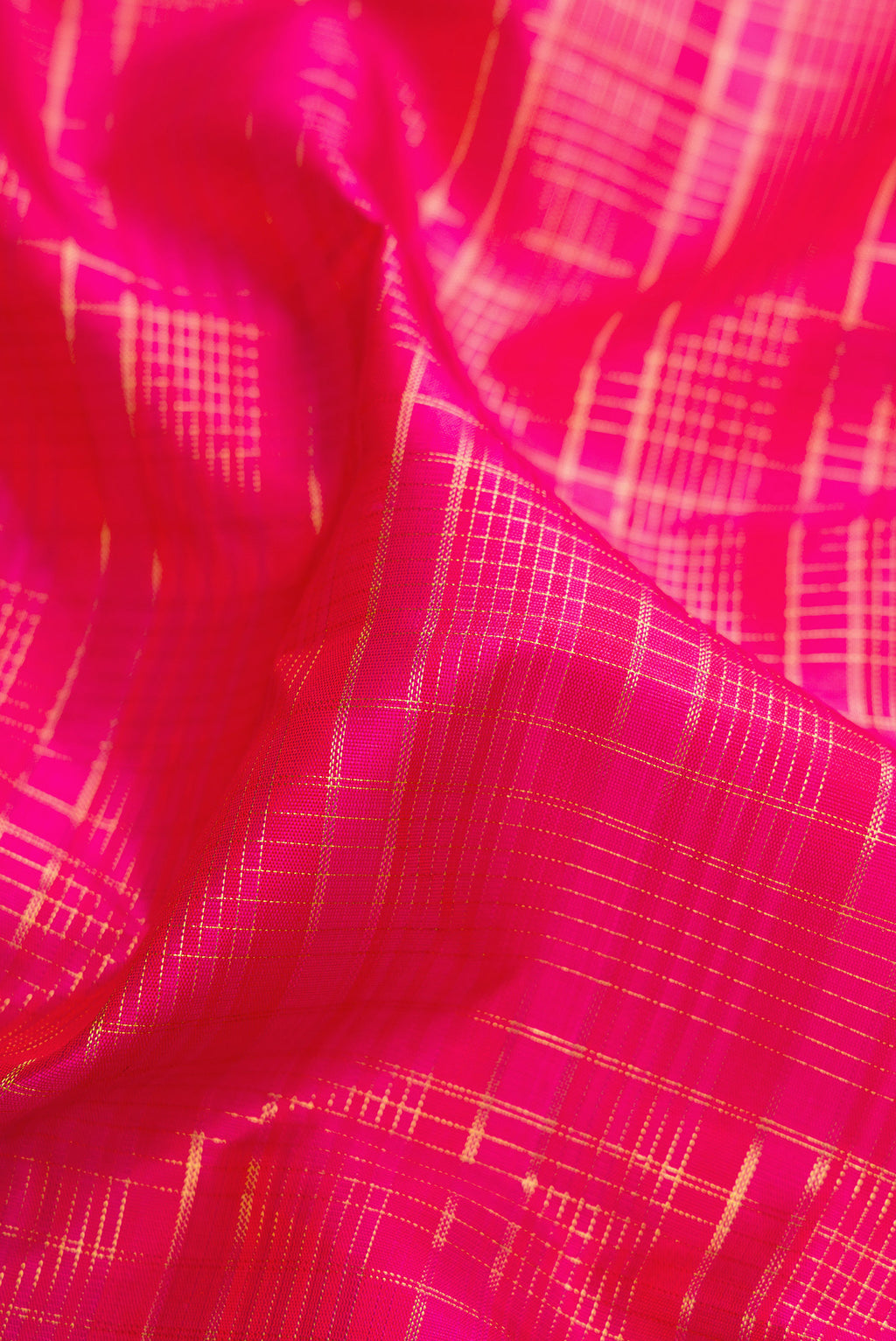 Close up of Dark Pink Kanjivaram Silk Saree with Checked design on the body and Zari Border.  displaying folds