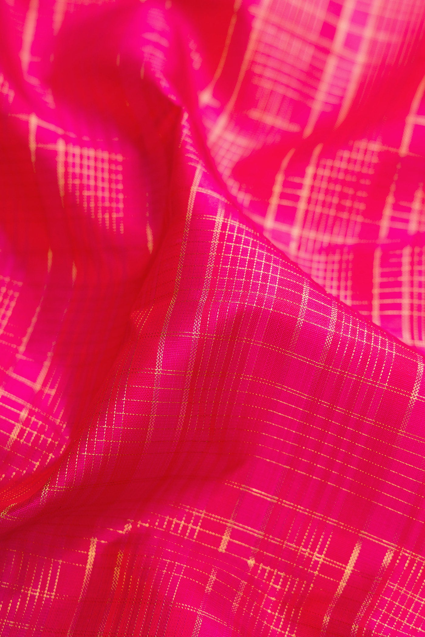 Close up of Dark Pink Kanjivaram Silk Saree with Checked design on the body and Zari Border.  displaying folds