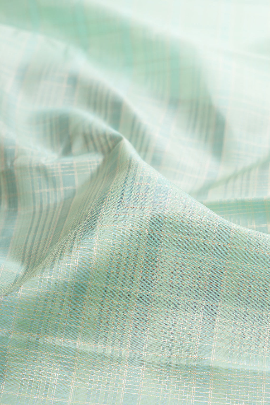 Close up of Mint Green Kanjivaram Silk Saree with Checked design on the body and Zari Border.  displaying folds