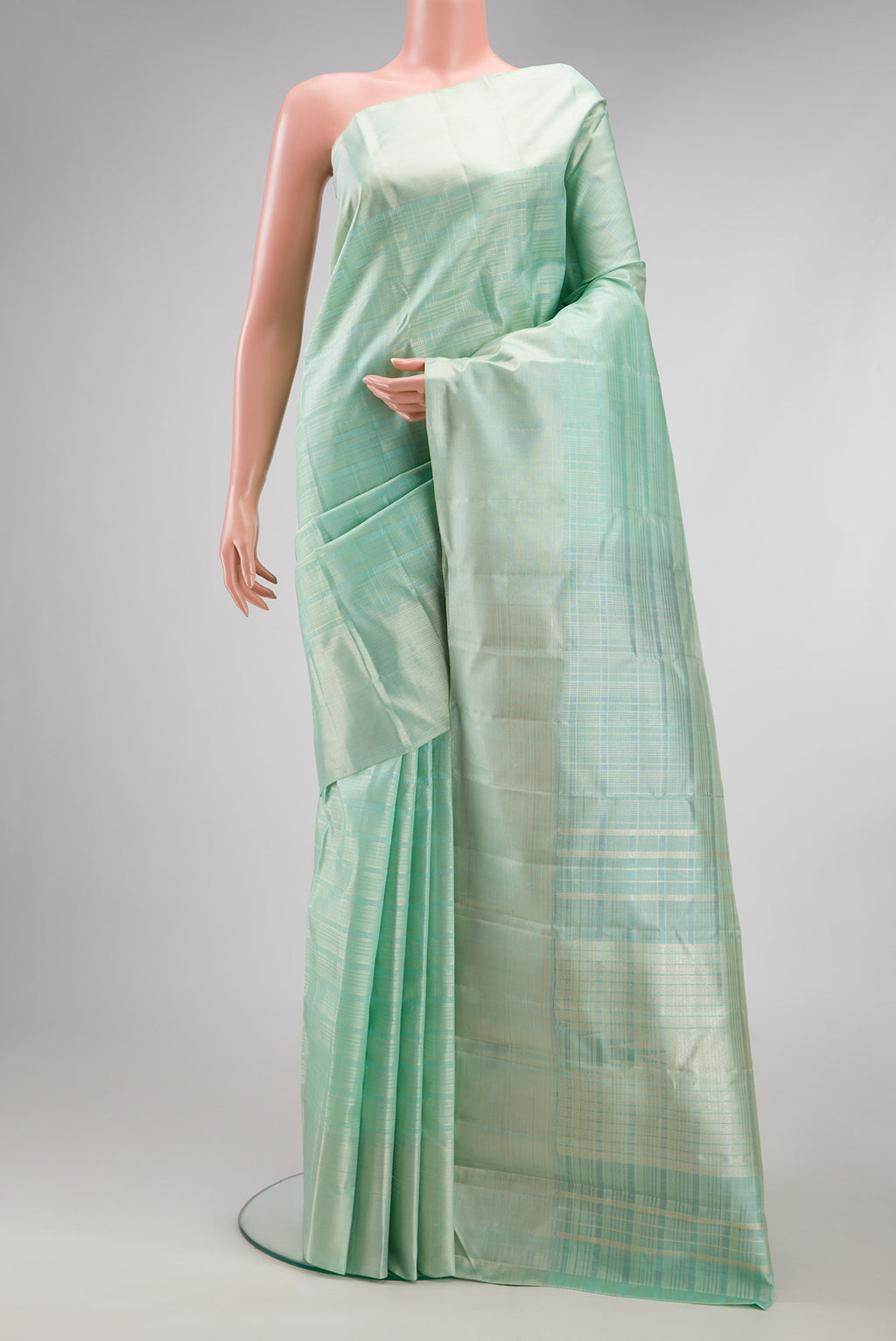 Mint Green Kanjivaram Silk Saree with Checked design on the body and Zari Border.  displayed on a mannequin