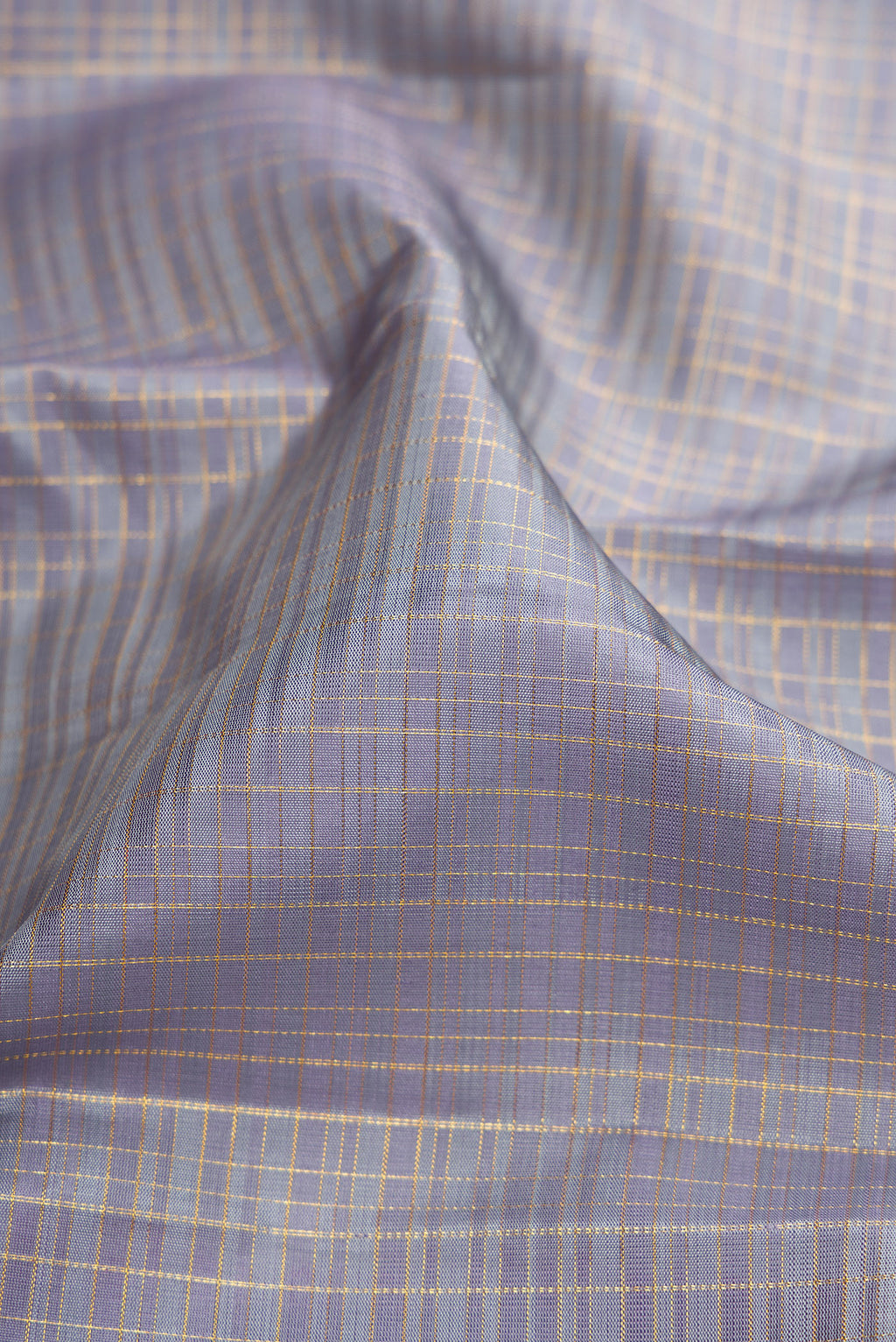 Close up of Grey Kanjivaram Silk Saree with Checked design on the body and Zari Border.  displaying folds