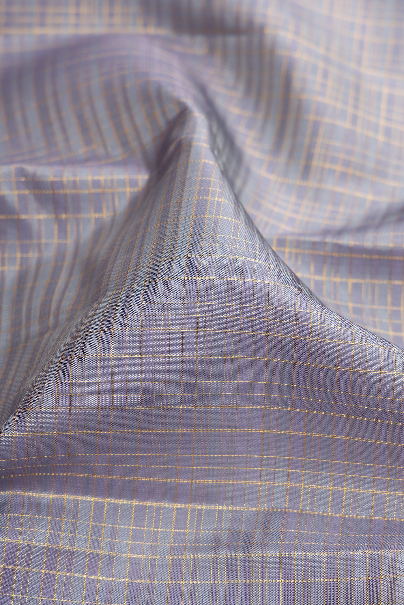 Close up of Grey Kanjivaram Silk Saree with Checked design on the body and Zari Border.  displaying folds