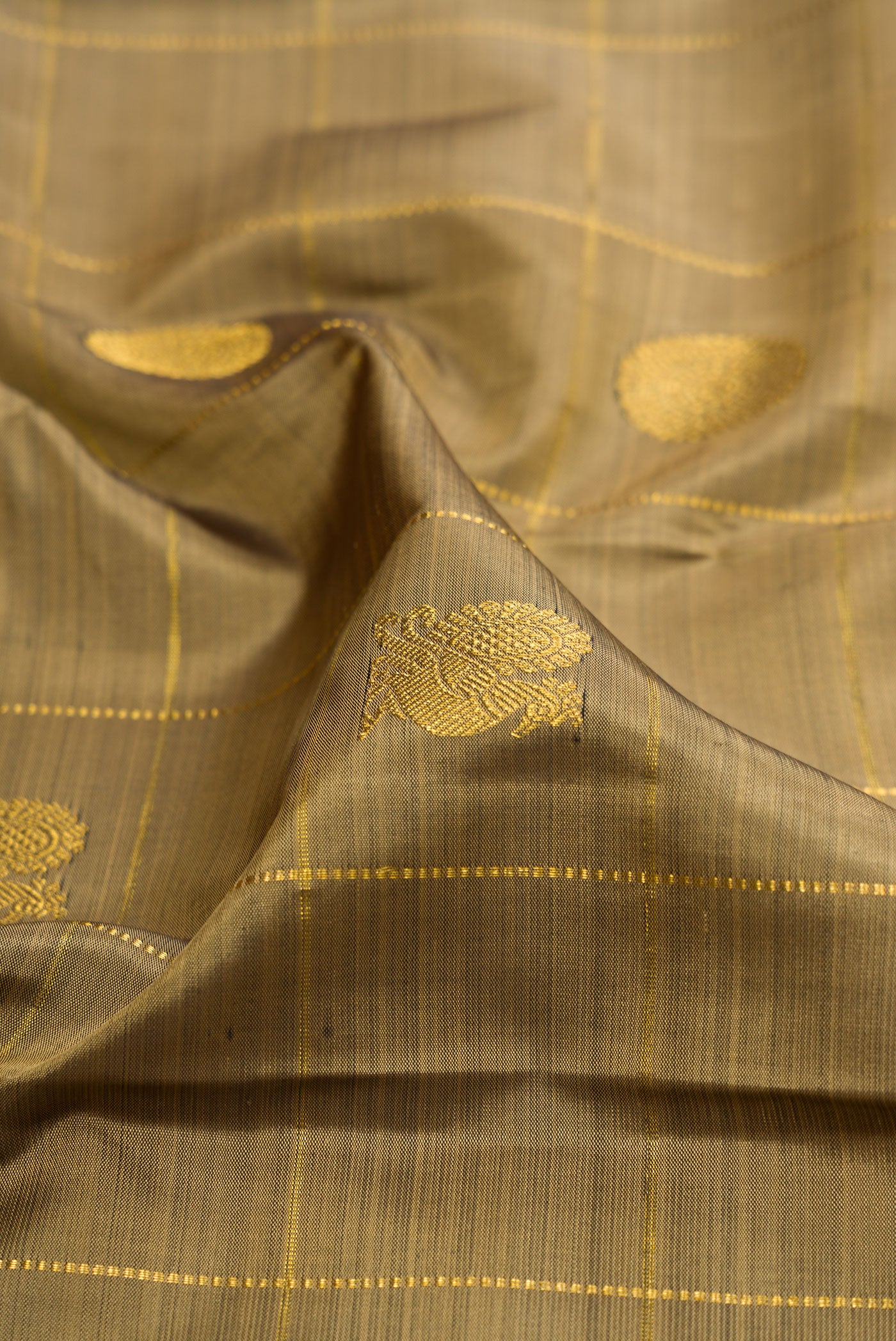 Close up of Mehandi Green Kanjivaram Silk Saree with Checked design on the body and Zari Border.  displaying folds
