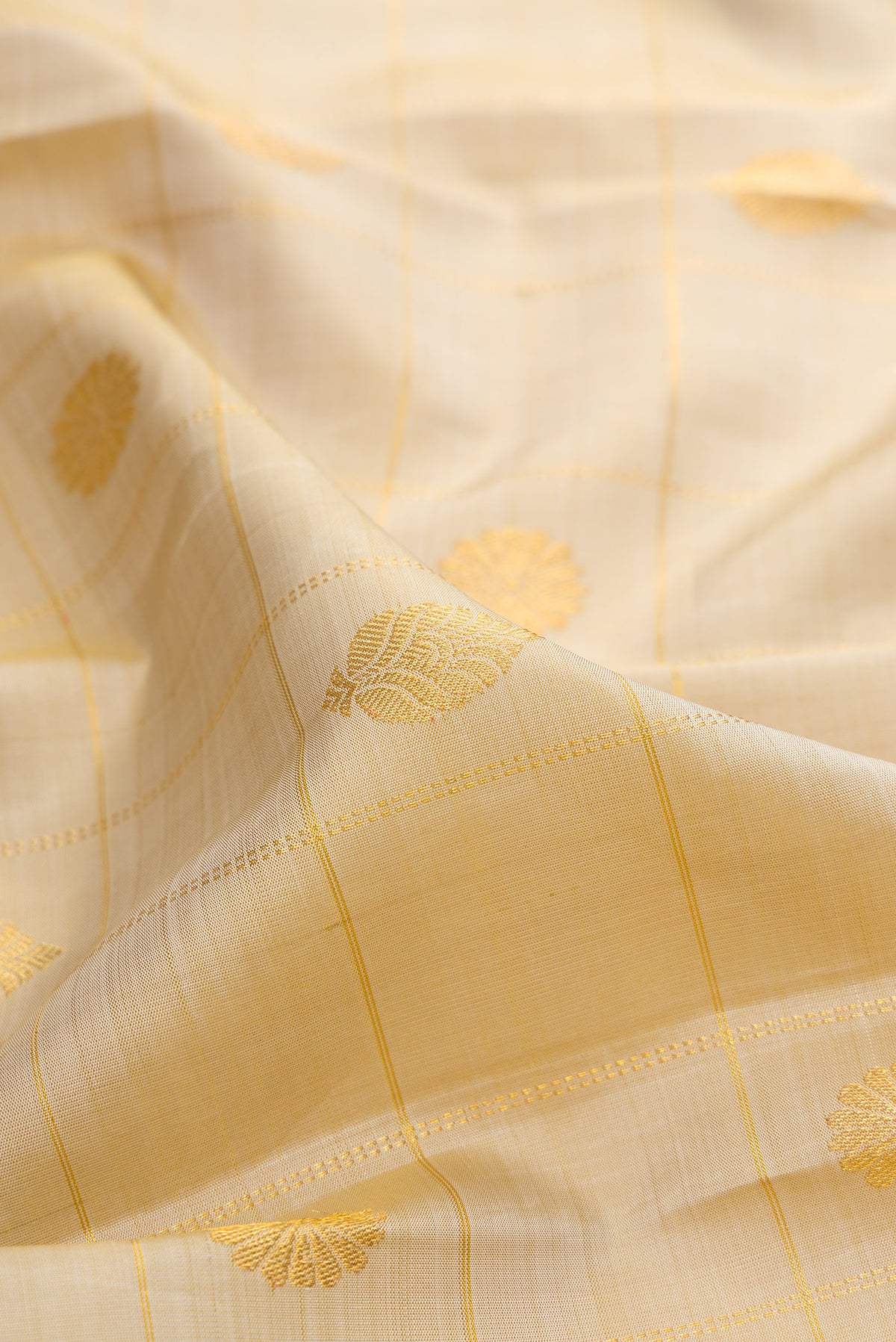 Close up of Pure Silk Beige Kanjivaram Saree with Checked design on the body and Zari Border.  displaying folds