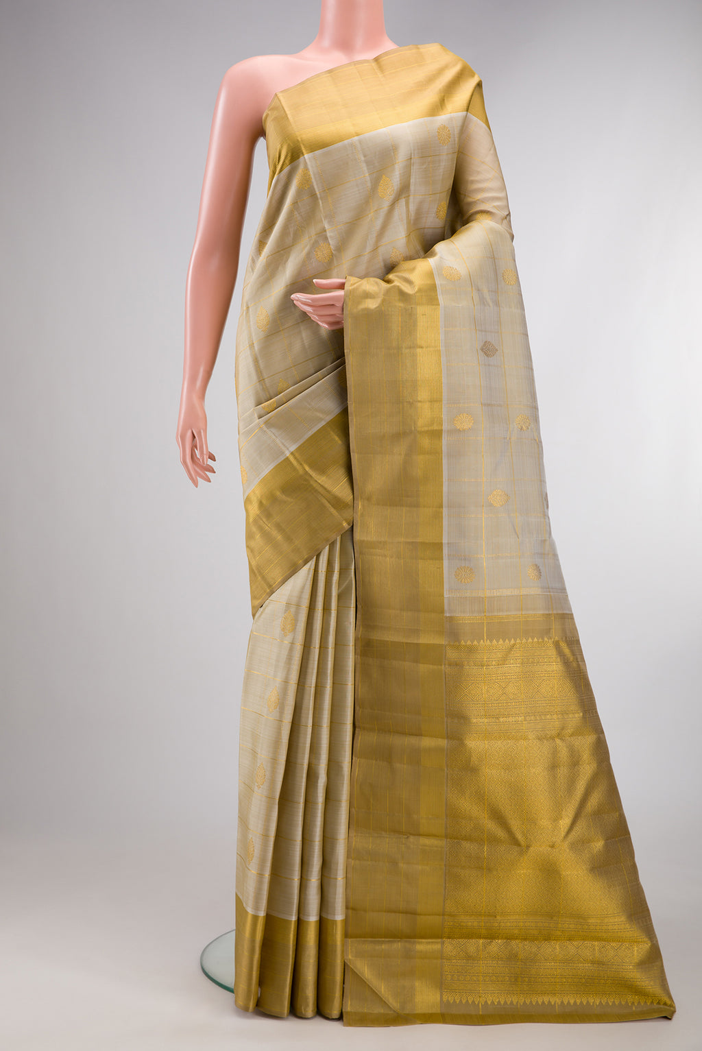 Pure Silk Beige Kanjivaram Saree with Checked design on the body and Zari Border.  displayed on a mannequin