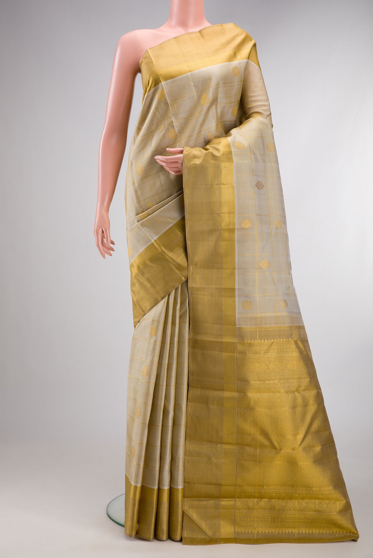 Pure Silk Beige Kanjivaram Saree with Checked design on the body and Zari Border.  displayed on a mannequin