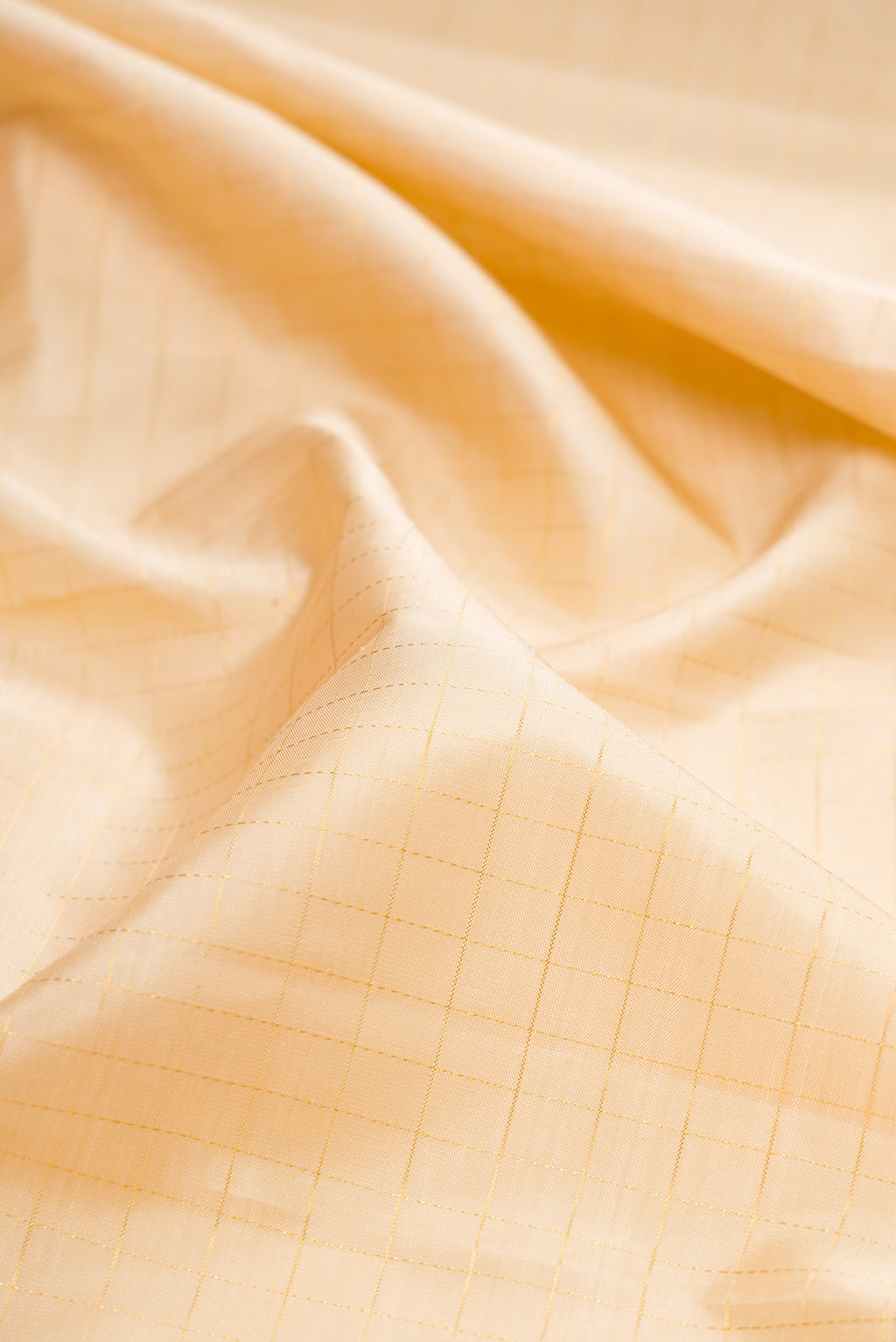 Close up of Beige Kanjivaram Silk Saree with Checked design on the body and Temple Border.  displaying folds