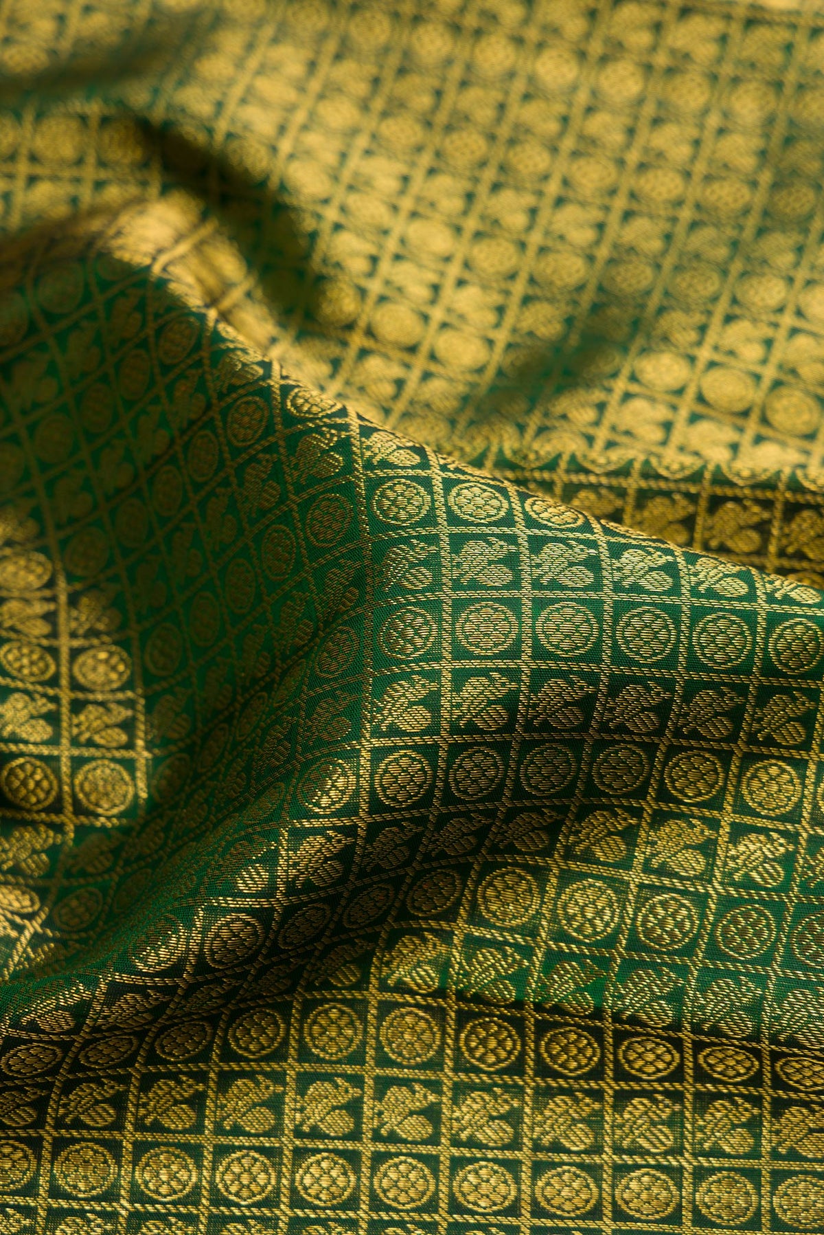 Close up of Pure Silk Bottle Green Dual Tone Kanchipuram Saree with Zari Brocade on the body and Zari Border.  displaying folds