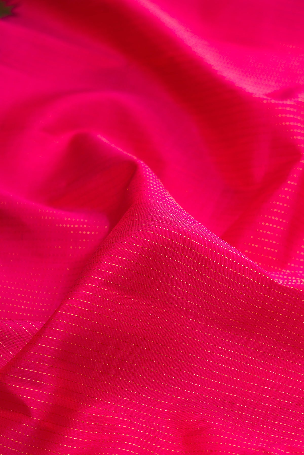 Close up of Pink Kanchipuram Silk Saree with Stripes on the body and Zari Border.  displaying folds
