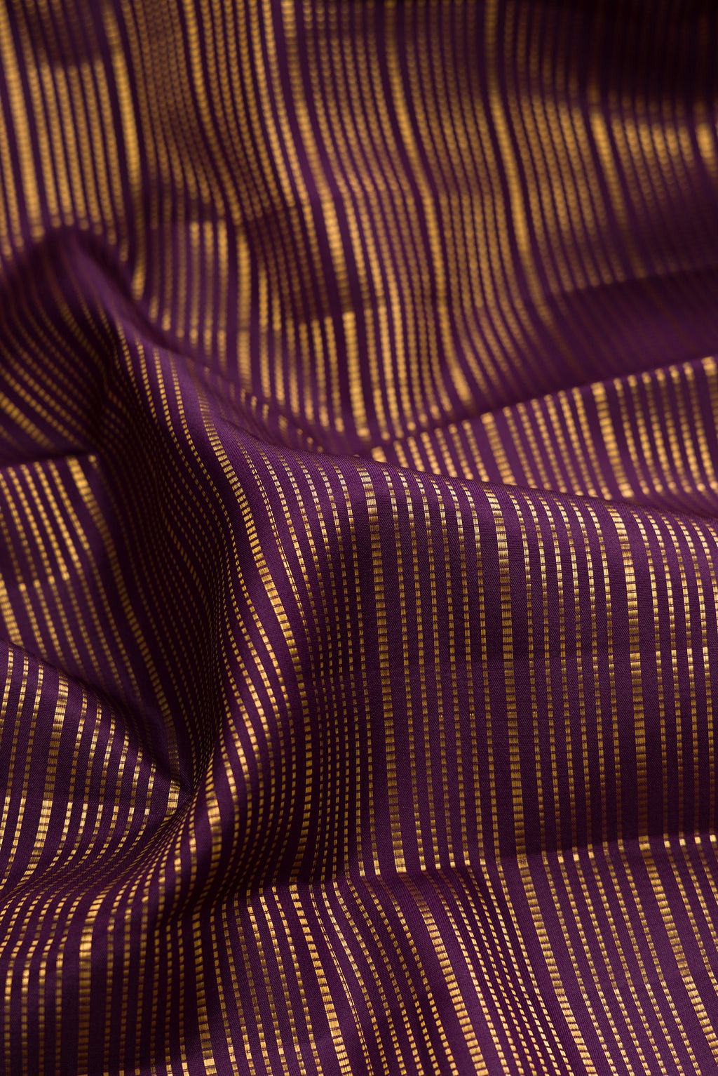Close up of Pure Silk Burgundy Dual Tone Kanjivaram Saree with Stripes on the body and Zari Border.  displaying folds