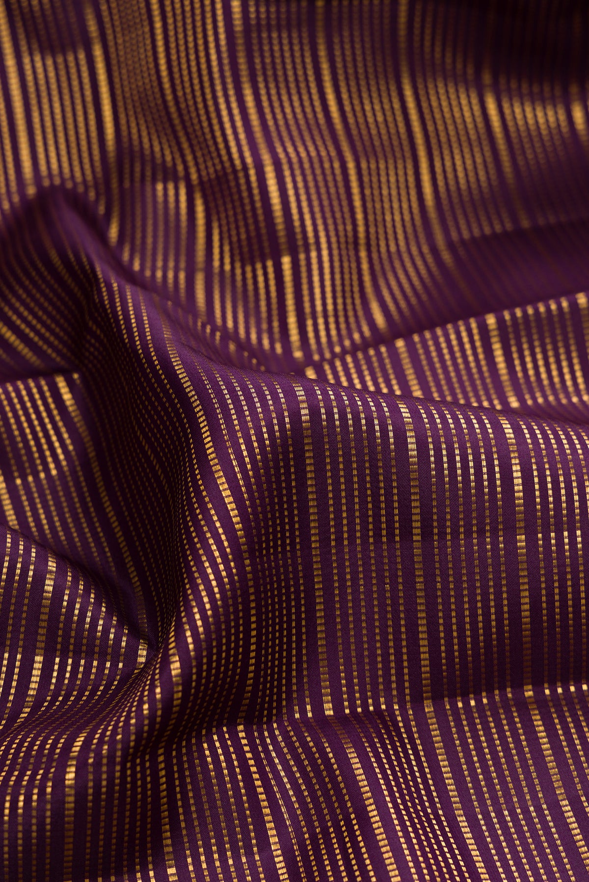 Close up of Pure Silk Burgundy Dual Tone Kanjivaram Saree with Stripes on the body and Zari Border.  displaying folds