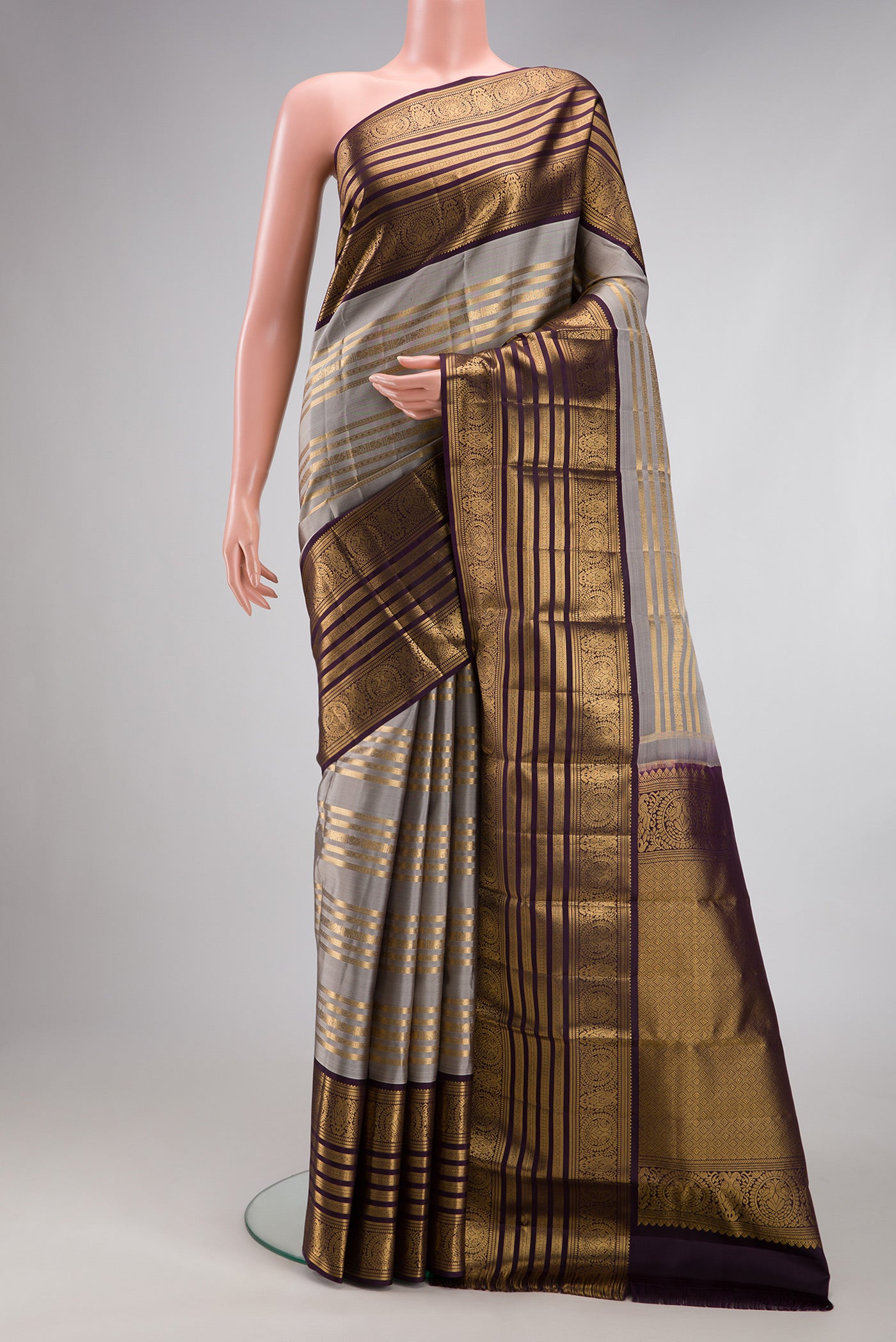 Grey Kanjivaram Silk Saree with Stripes on the body and Zari Border.  displayed on a mannequin