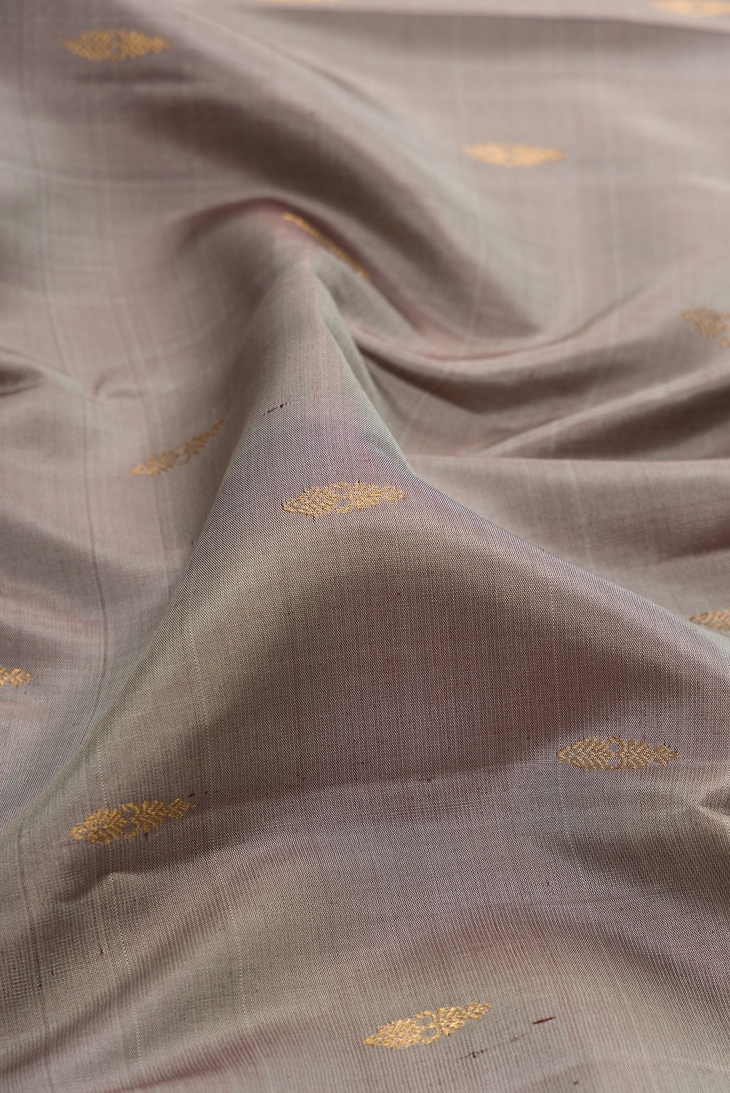 Close up of Grey Kanjivaram Silk Saree with Zari Butta on the body and Zari Border.  displaying folds