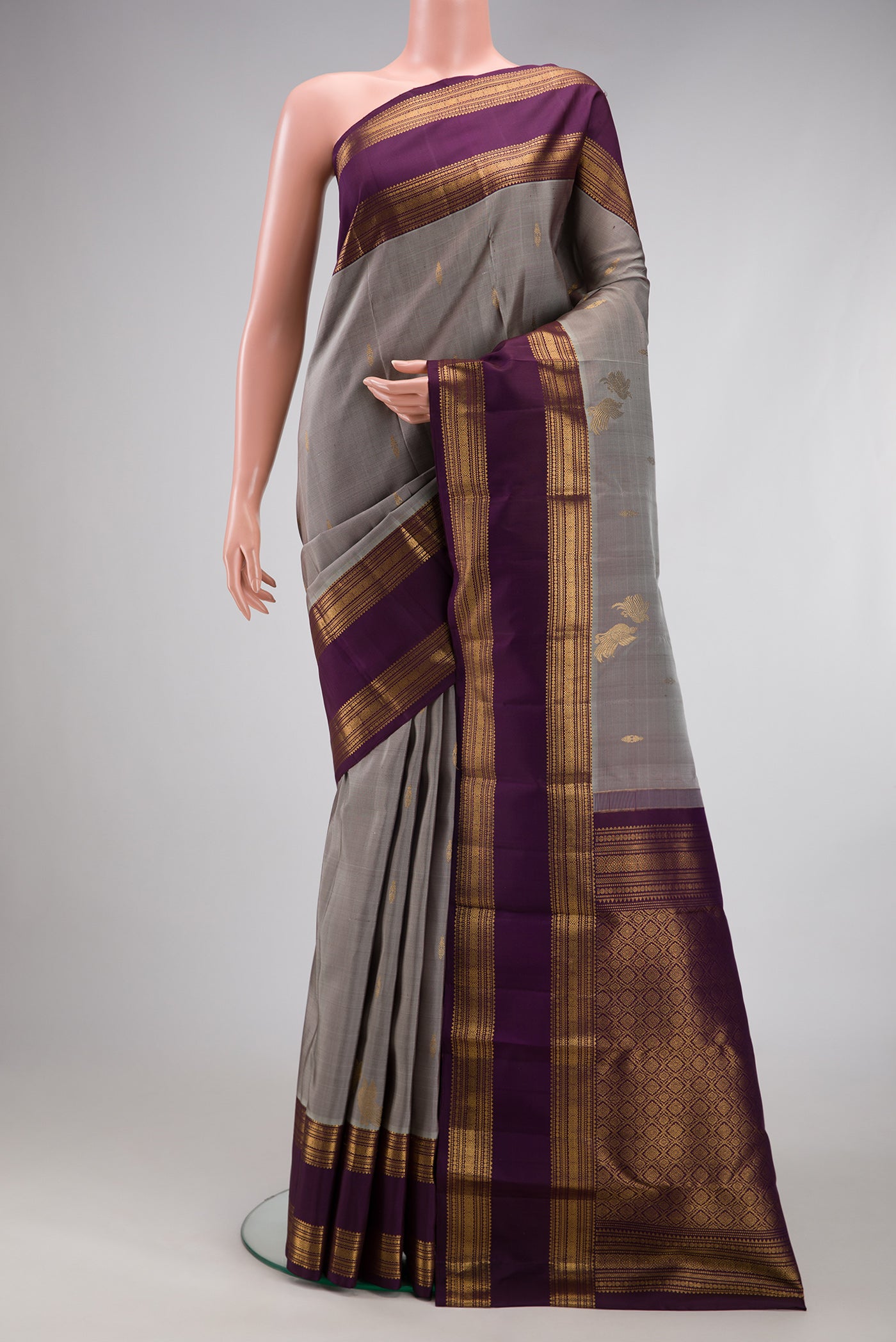 Grey Kanjivaram Silk Saree with Zari Butta on the body and Zari Border.  displayed on a mannequin
