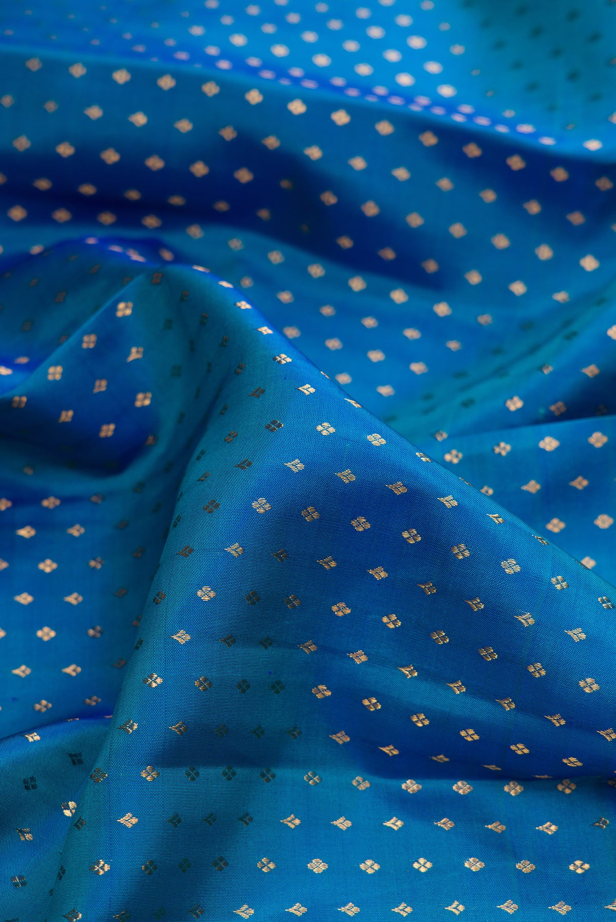 Close up of Pure Silk Blue Kanjivaram Saree with Zari Butta on the body and Zari Border.  displaying folds