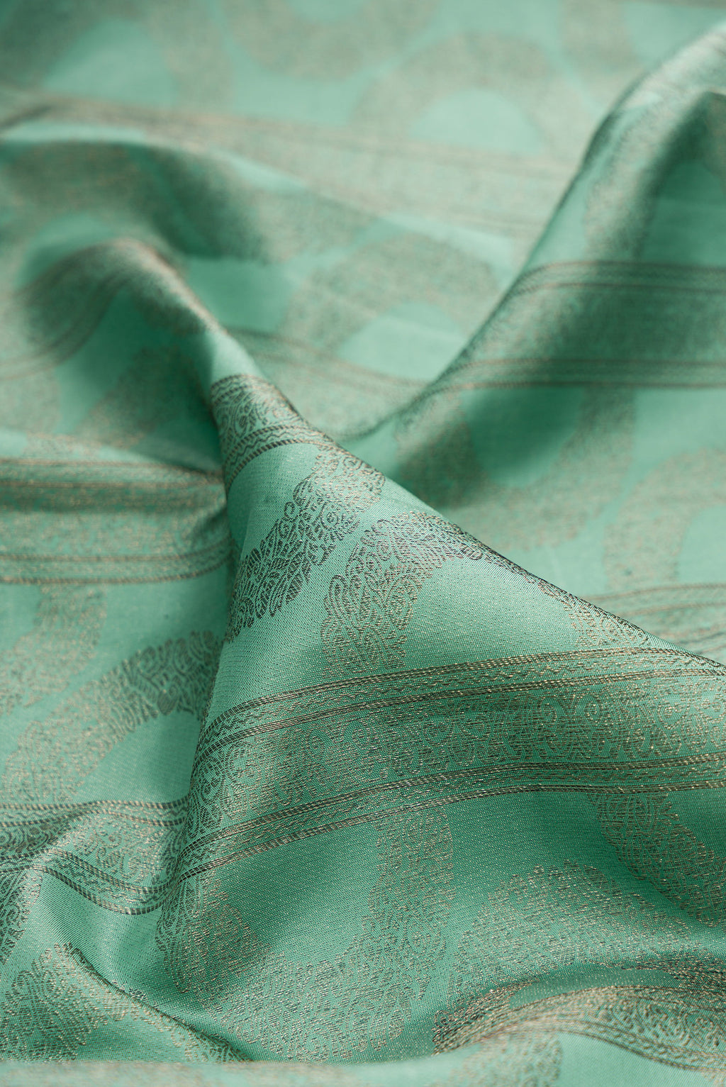 Close up of Pure Silk Sea Green Kanjivaram Saree with Zari Brocade on the body and Fancy Border.  displaying folds