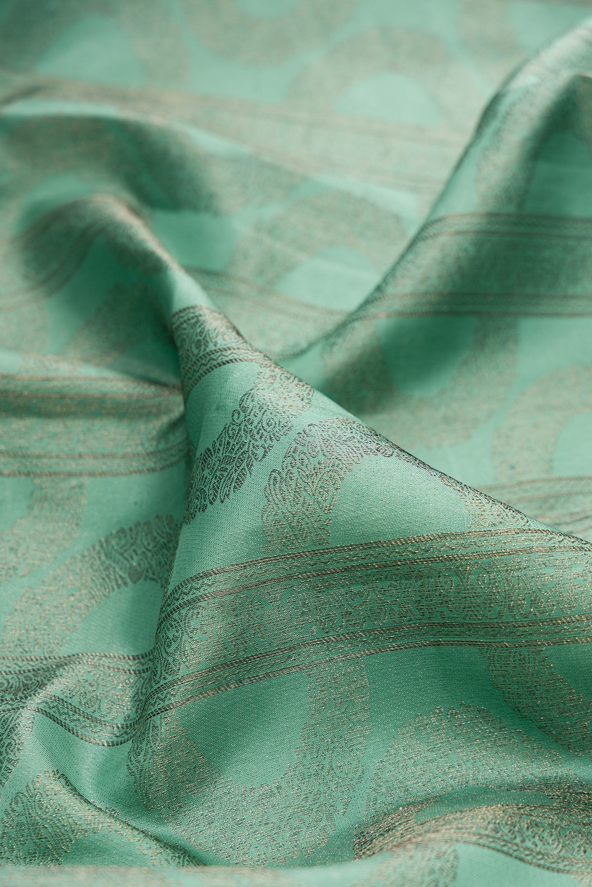 Close up of Pure Silk Sea Green Kanjivaram Saree with Zari Brocade on the body and Fancy Border.  displaying folds