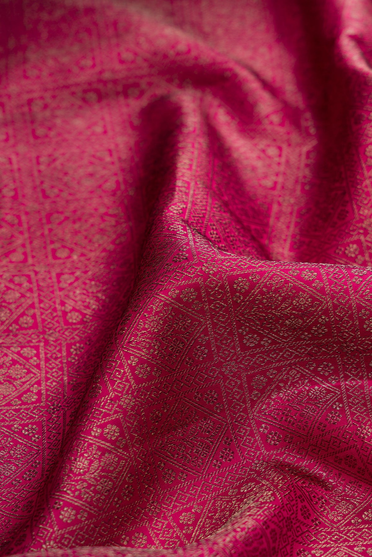 Close up of Pure Silk Dark Pink Kanjivaram Saree with Zari Brocade on the body and Fancy Border.  displaying folds