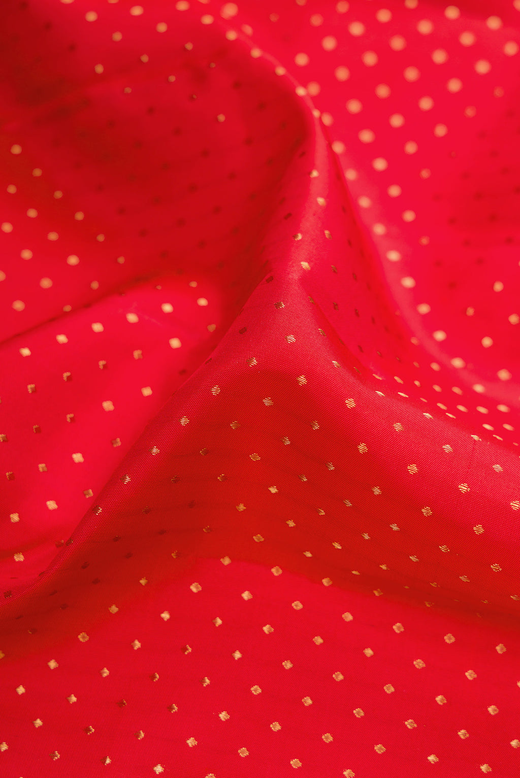 Close up of Red Kanjivaram Silk Saree with Zari Butta on the body and Fancy Border.  displaying folds