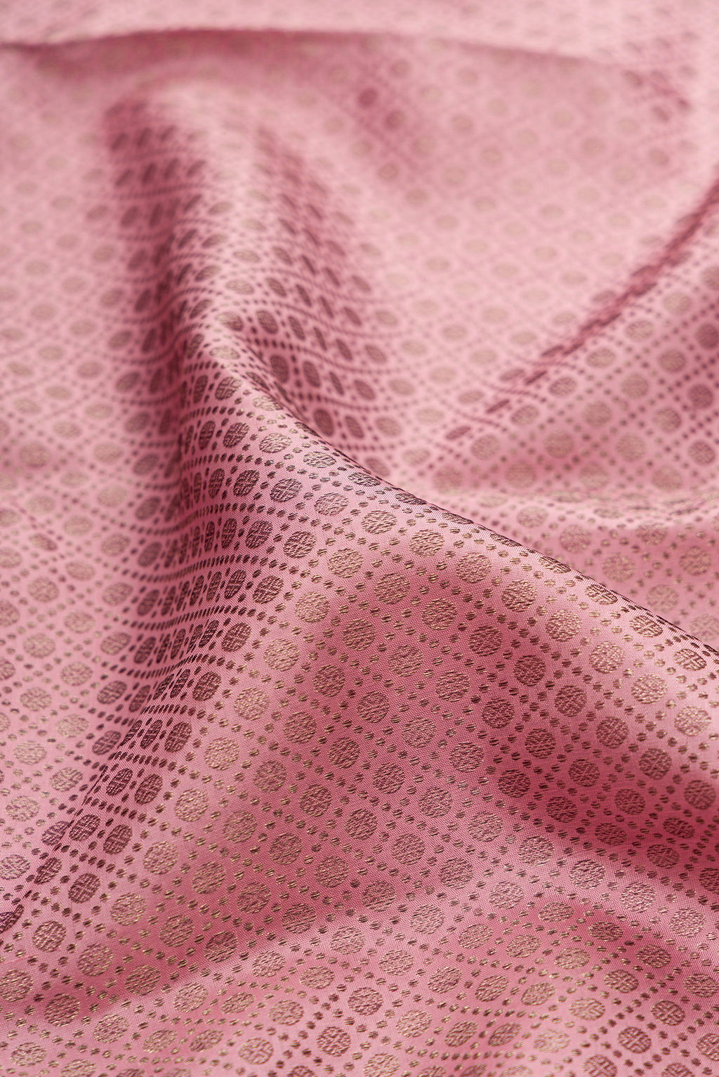 Close up of Pure Silk Rose Gold Dual Tone Kanjivaram Saree with Zari Brocade on the body and Fancy Border.  displaying folds