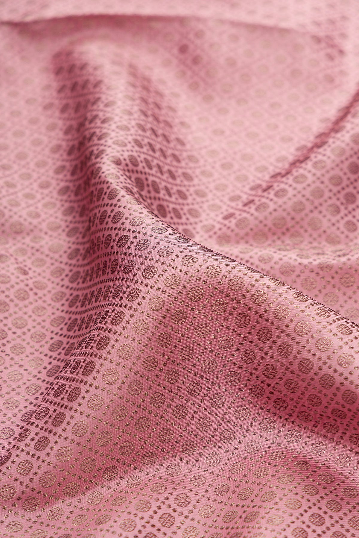 Close up of Pure Silk Rose Gold Dual Tone Kanjivaram Saree with Zari Brocade on the body and Fancy Border.  displaying folds
