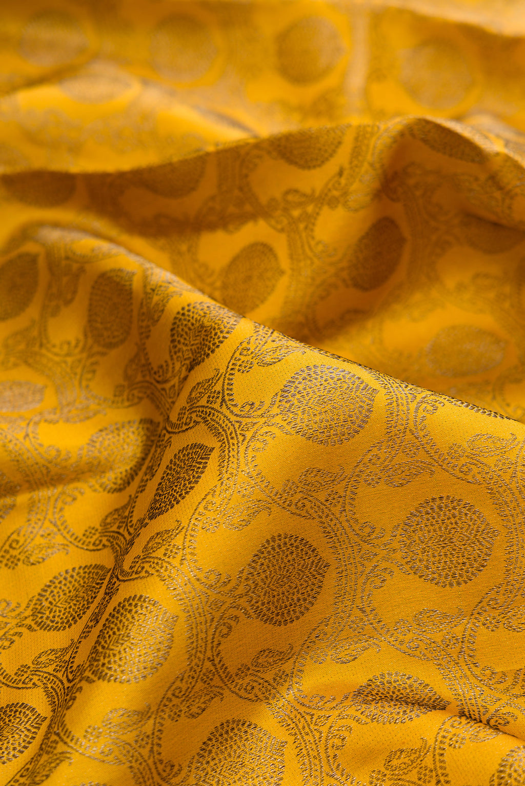 Close up of Pure Silk Mustard Kanjivaram Saree with Zari Brocade on the body and Zari Border.  displaying folds