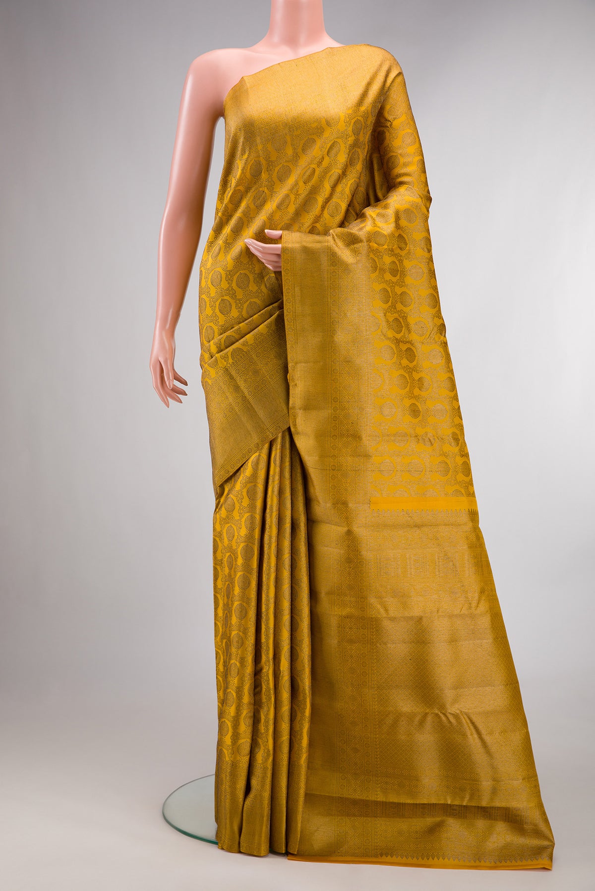 Pure Silk Mustard Kanjivaram Saree with Zari Brocade on the body and Zari Border.  displayed on a mannequin