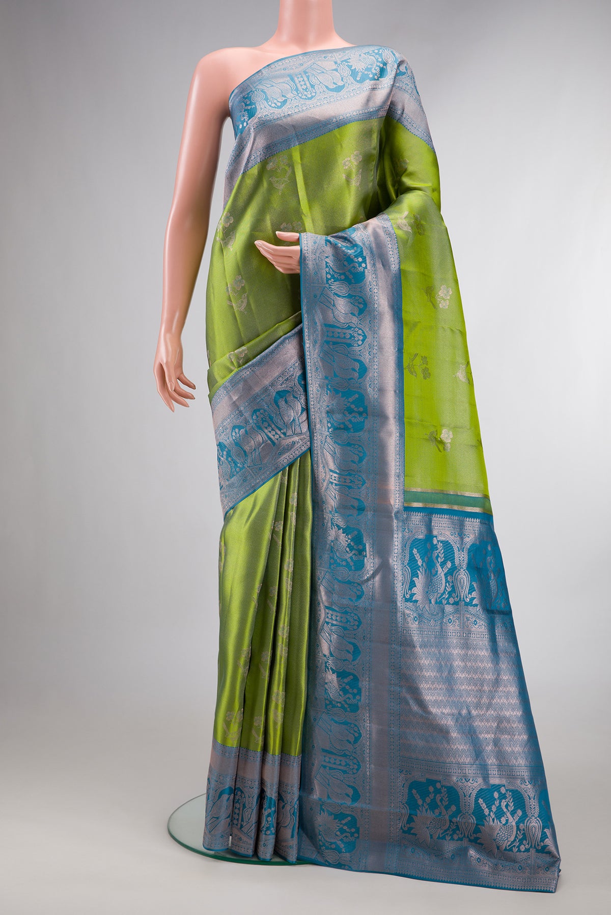Green Dual Tone Kanjivaram Tissue Saree with Zari Brocade on the body and Zari Border.  displayed on a mannequin