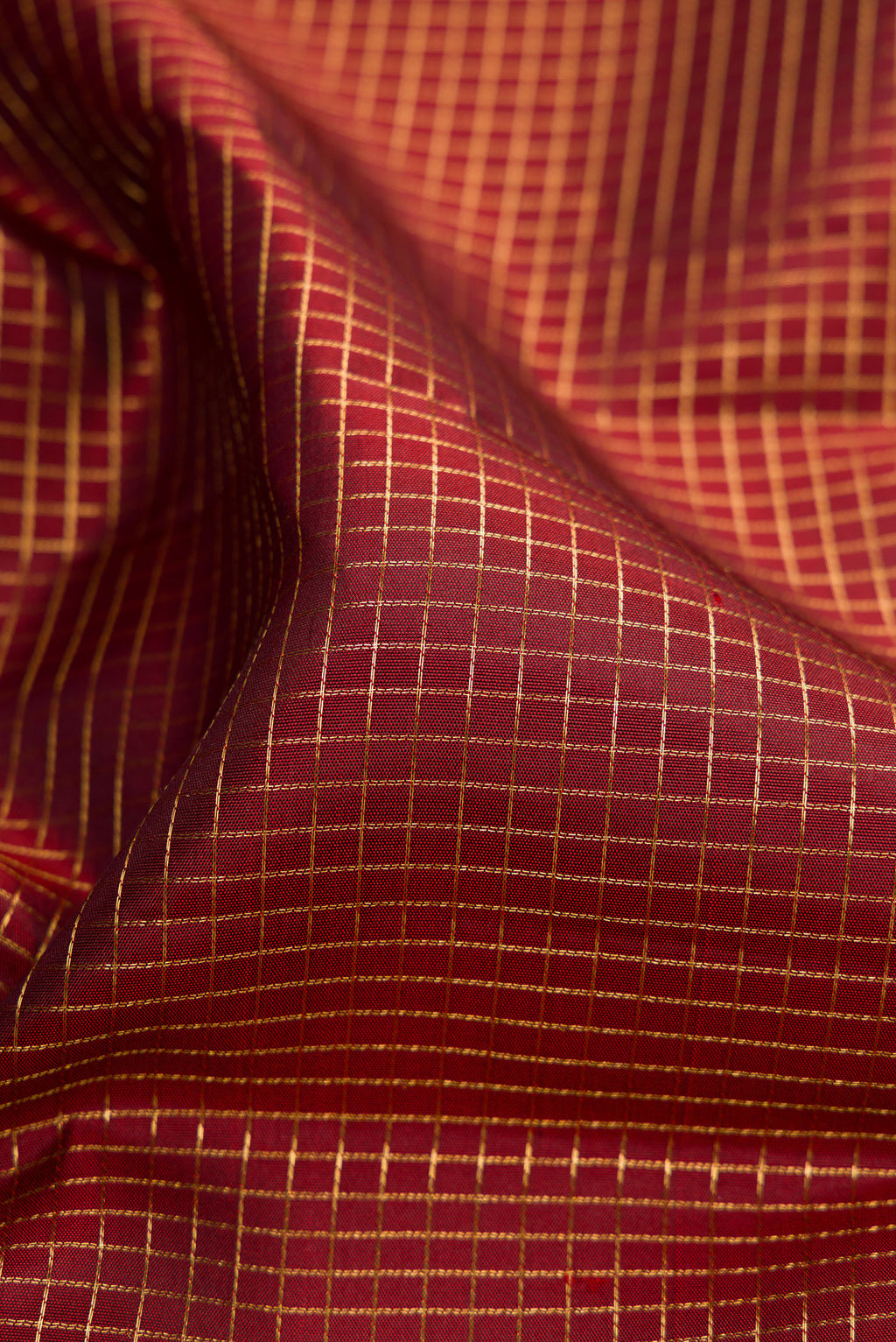 Close up of Maroon Kanjivaram Silk Saree with Checked design on the body and Zari Border.  displaying folds