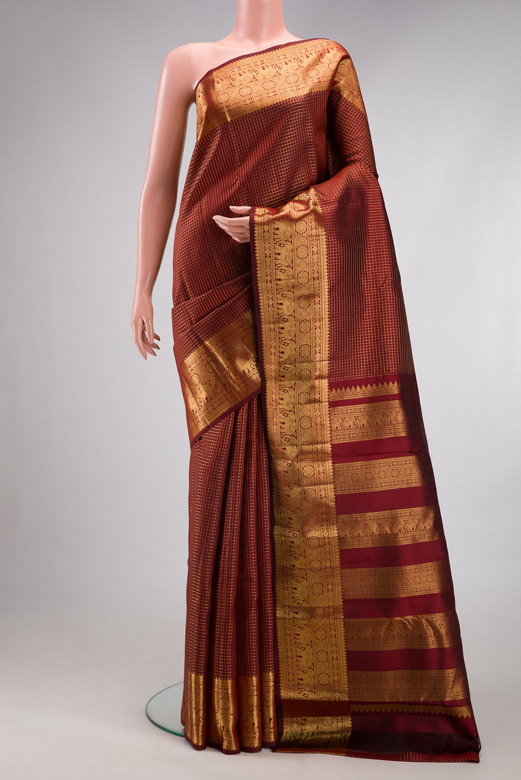 Maroon Kanjivaram Silk Saree with Checked design on the body and Zari Border.  displayed on a mannequin