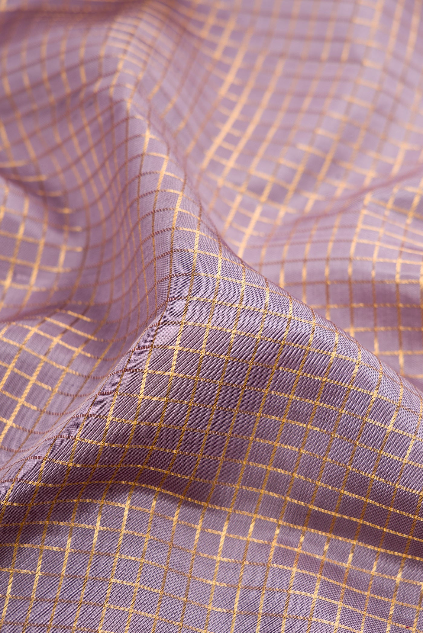 Close up of Lilac Kanjivaram Silk Saree with Checked design on the body and Zari Border.  displaying folds