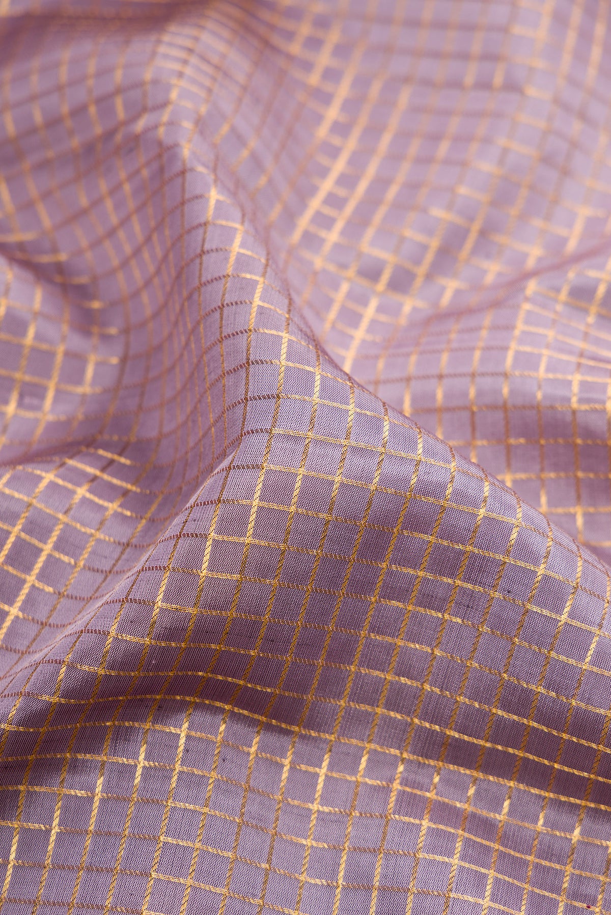 Close up of Lilac Kanjivaram Silk Saree with Checked design on the body and Zari Border.  displaying folds