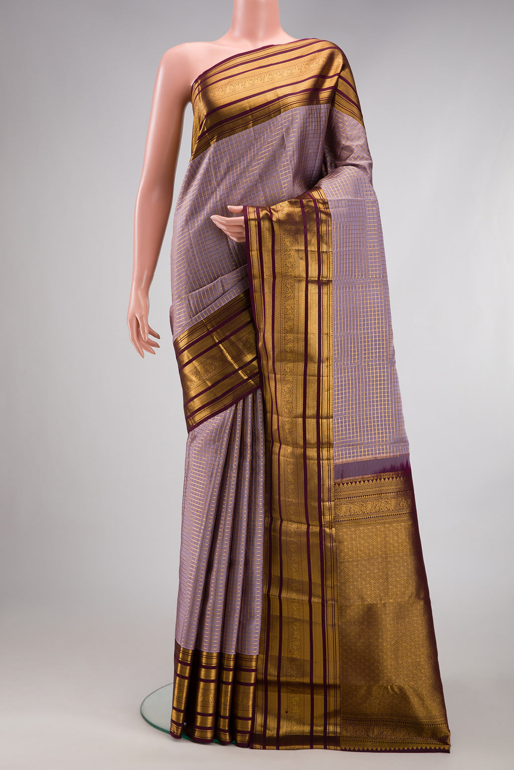 Lilac Kanjivaram Silk Saree with Checked design on the body and Zari Border.  displayed on a mannequin