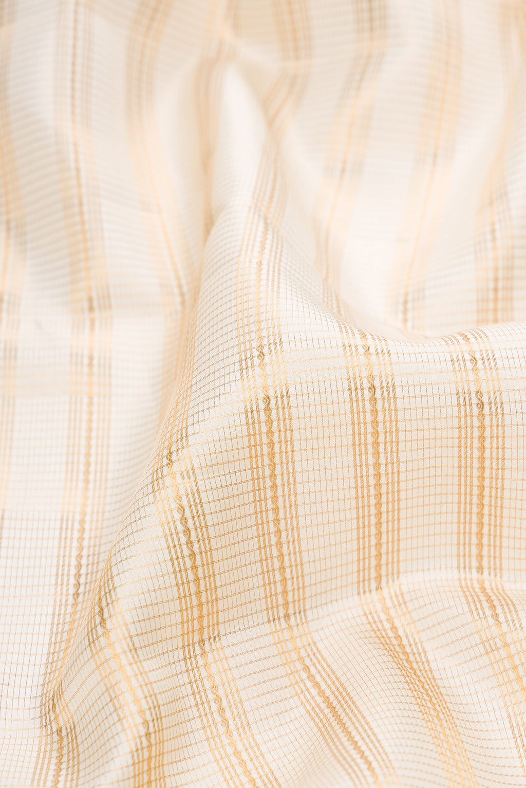 Close up of Cream Kanjivaram Silk Saree with Stripes on the body and Zari Border.  displaying folds