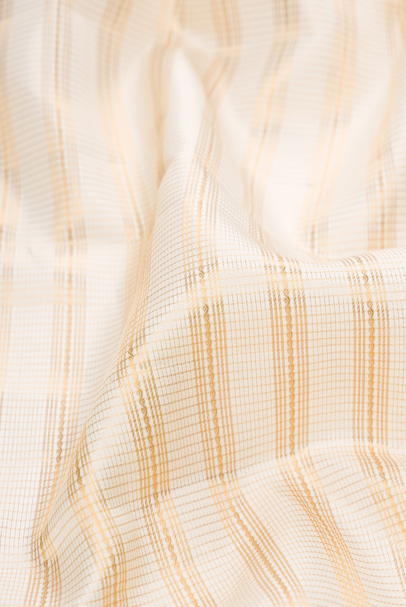 Close up of Cream Kanjivaram Silk Saree with Stripes on the body and Zari Border.  displaying folds