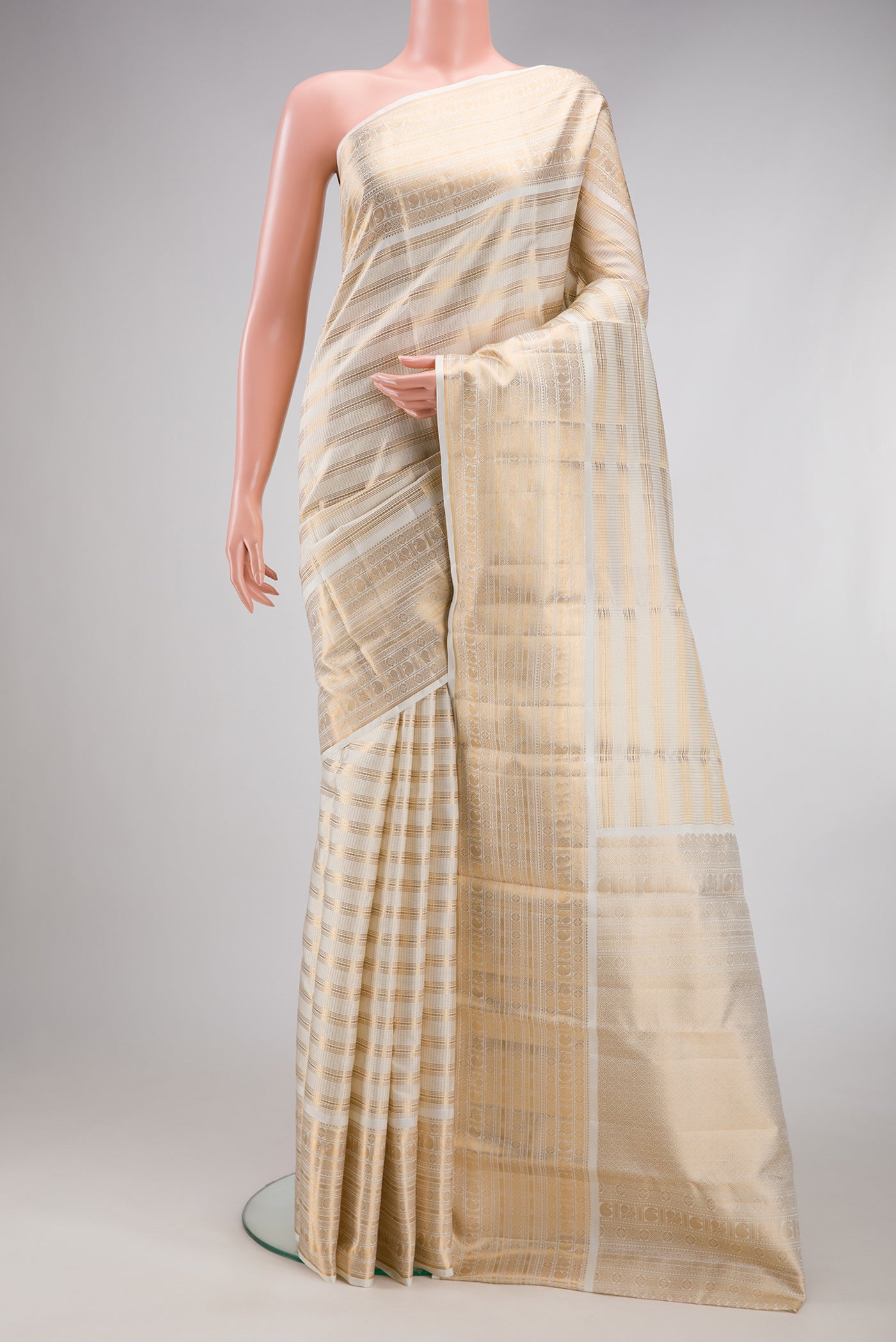 Cream Kanjivaram Silk Saree with Stripes on the body and Zari Border.  displayed on a mannequin