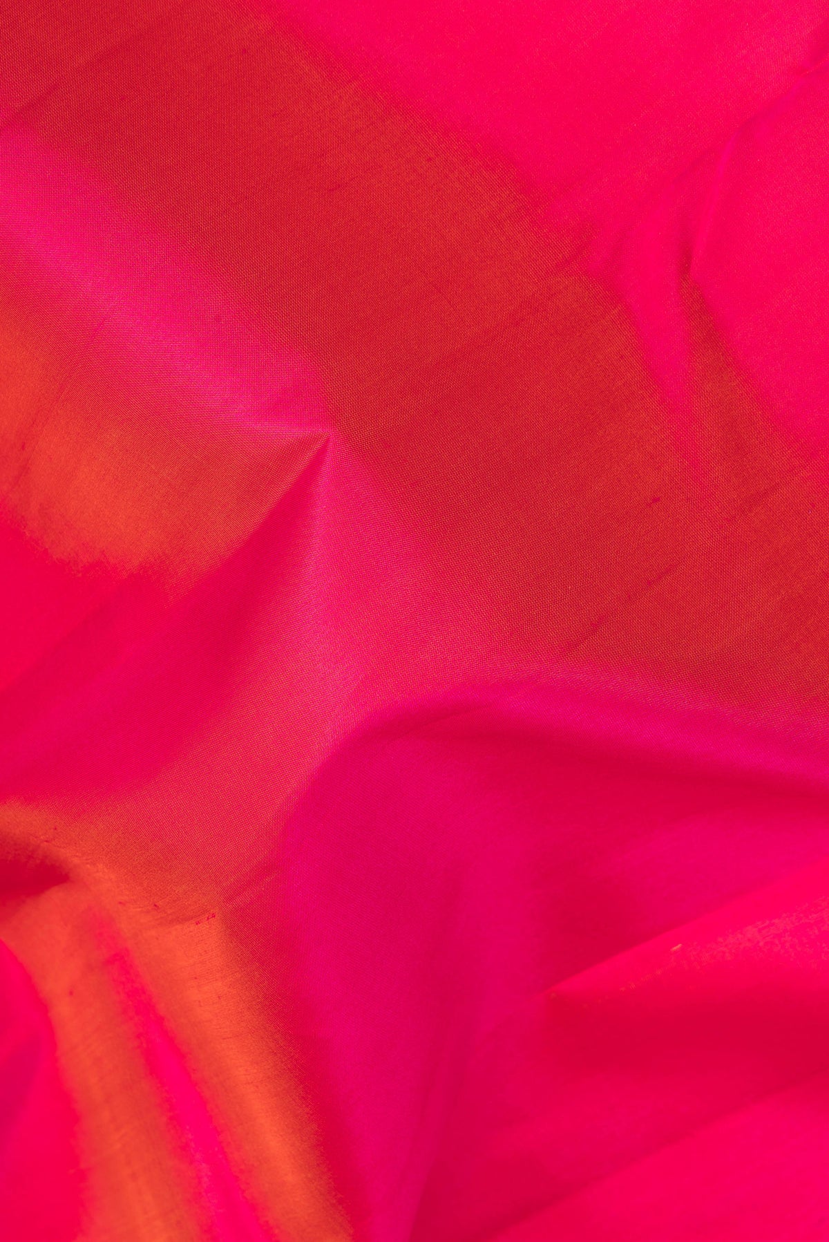 Close up of Pure Silk Coral Dual Tone Kanjivaram Saree with Plain Body and Zari Border.  displaying folds