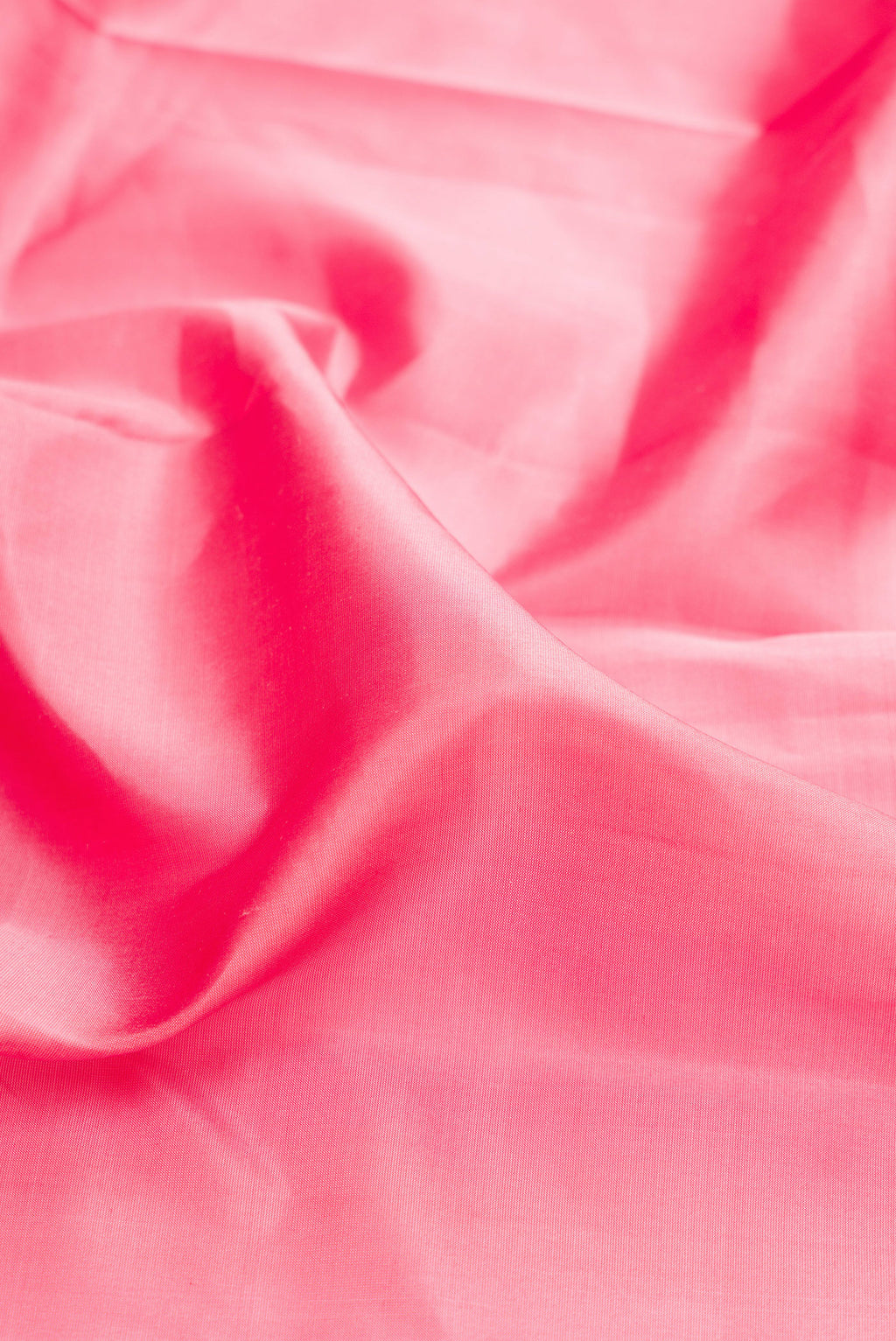 Close up of Rose pink Kanjivaram Silk Saree with Plain Body and Zari Border.  displaying folds
