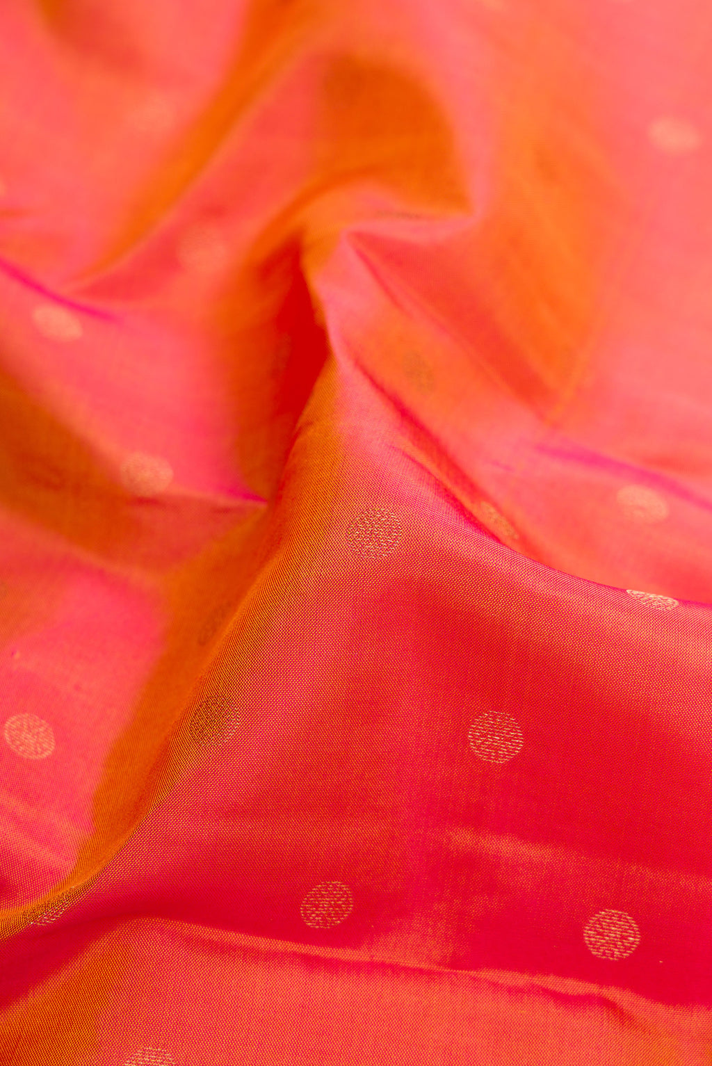 Close up of Gold Dual Tone Kanchipuram Silk Saree with Zari Butta on the body and Fancy Border.  displaying folds
