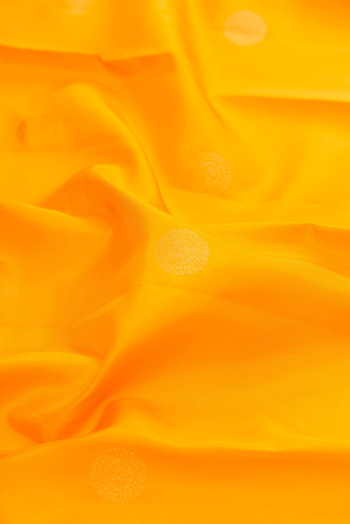 Close up of Mustard Dual Tone Kanchipuram Silk Saree with Zari Butta on the body and Zari Border.  displaying folds
