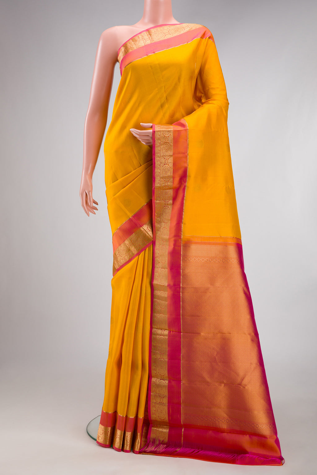Mustard Dual Tone Kanchipuram Silk Saree with Zari Butta on the body and Zari Border.  displayed on a mannequin